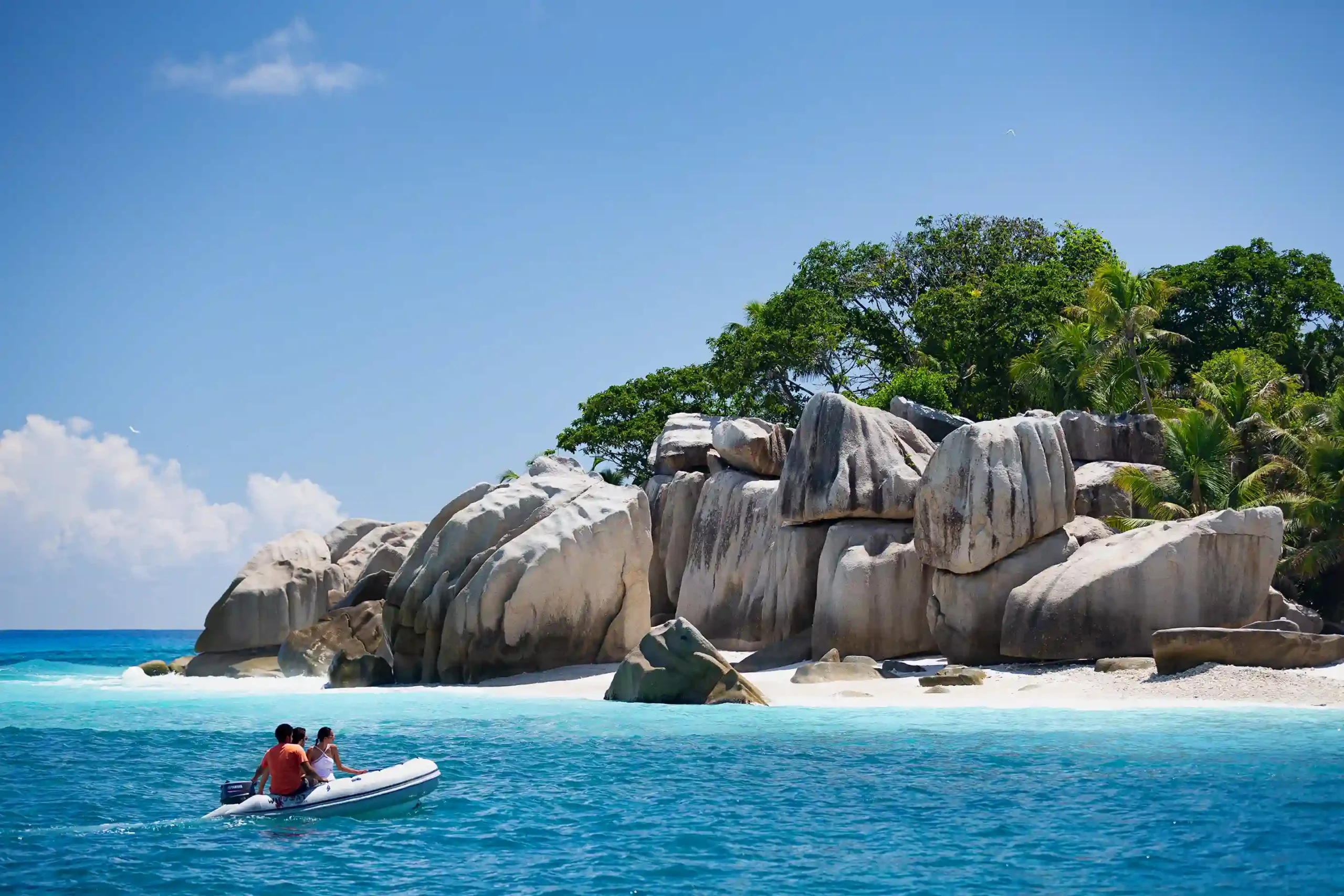 speed boat cruising on turquoise waters near raffles seychelles with tropical islands in the background