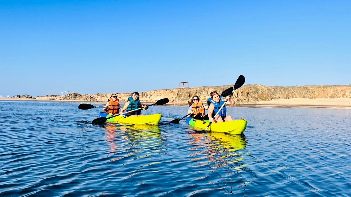 salalah oman person kayaking on calm blue water with scenic background