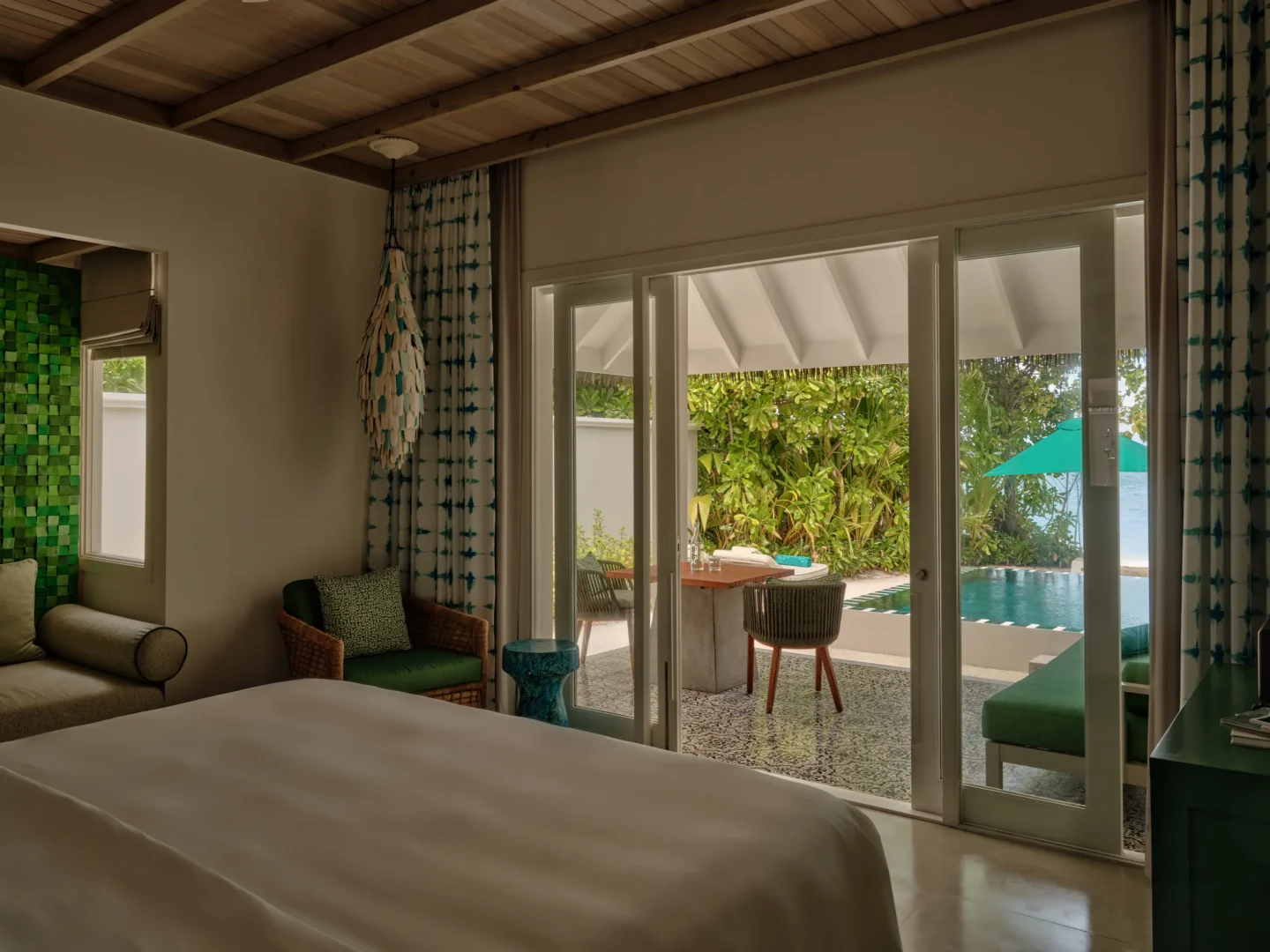 seaside finolhu beach pool villa bedroom featuring elegant coastal design warm natural textures and serene maldives island ambience