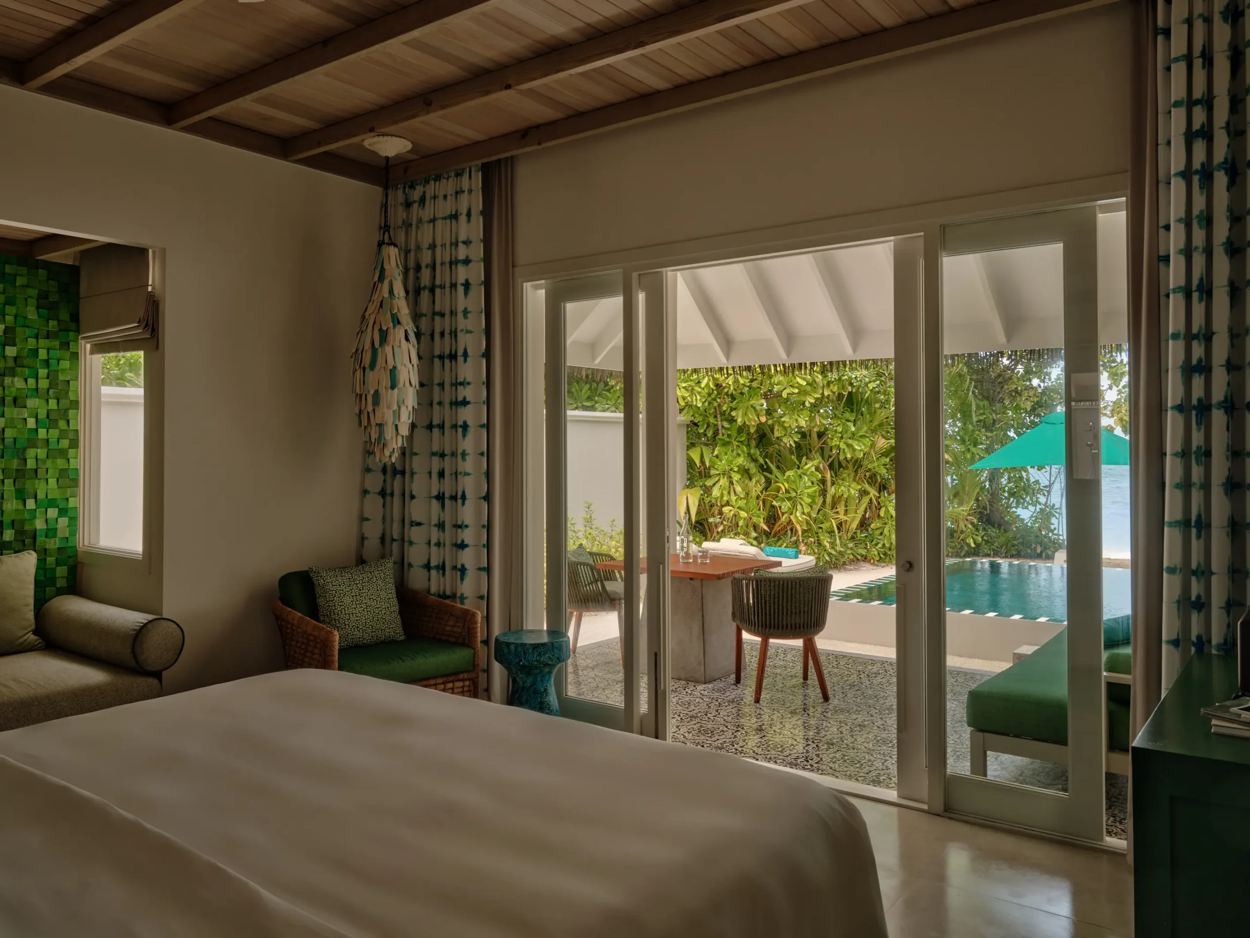 seaside finolhu beach pool villa bedroom featuring elegant coastal design warm natural textures and serene maldives island ambience