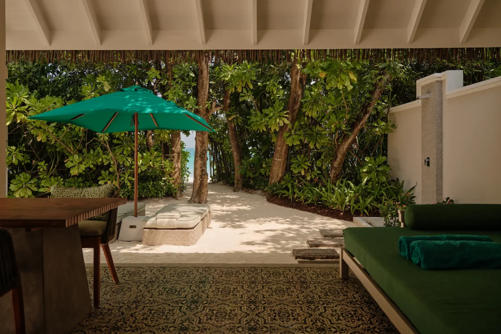 seaside finolhu beach villa terrace with private outdoor lounging space lush tropical greenery and serene maldives island ambience