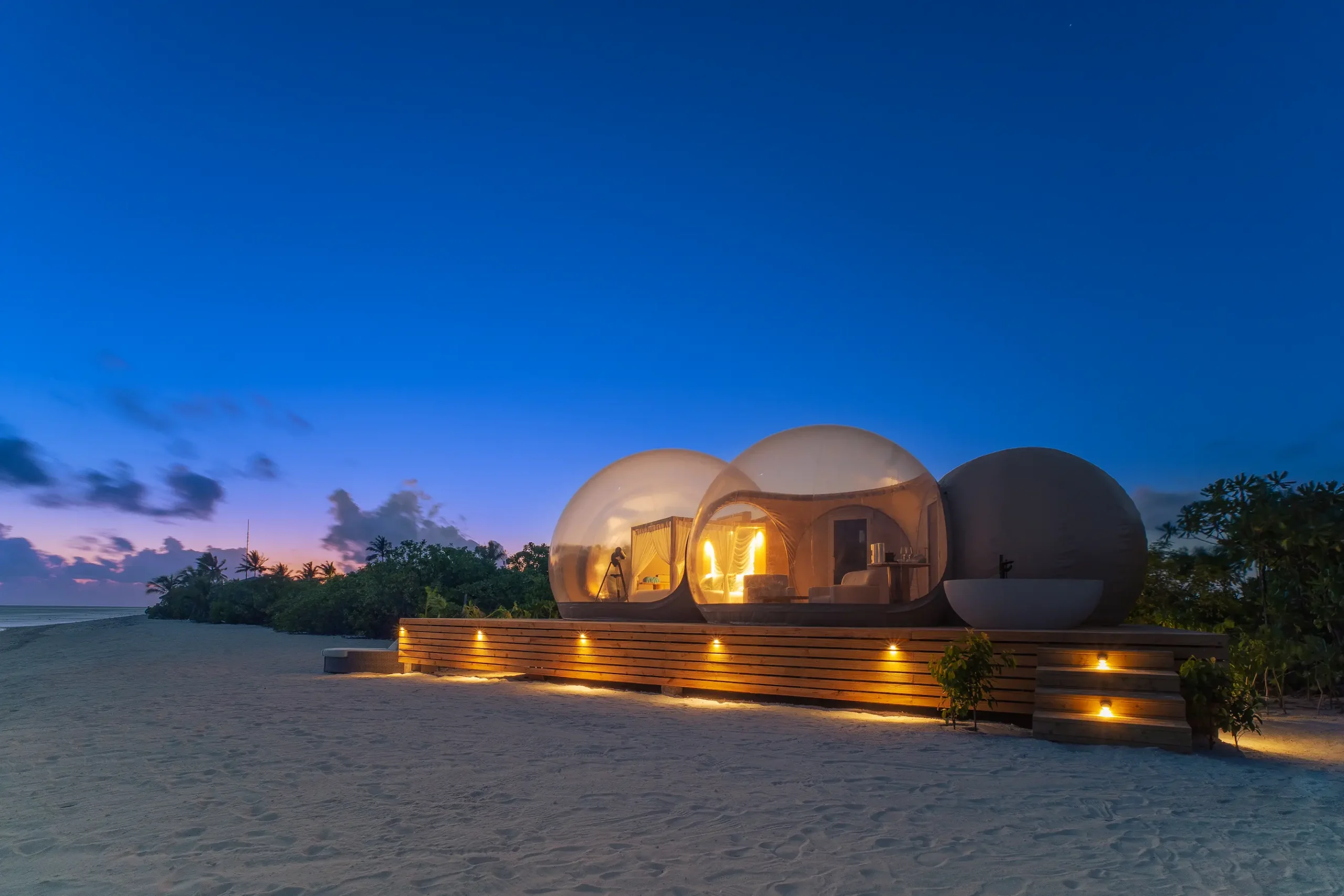 seaside finolhu maldives beach bubble by night intimate starlit bubble suite glowing softly against the tranquil beachfront