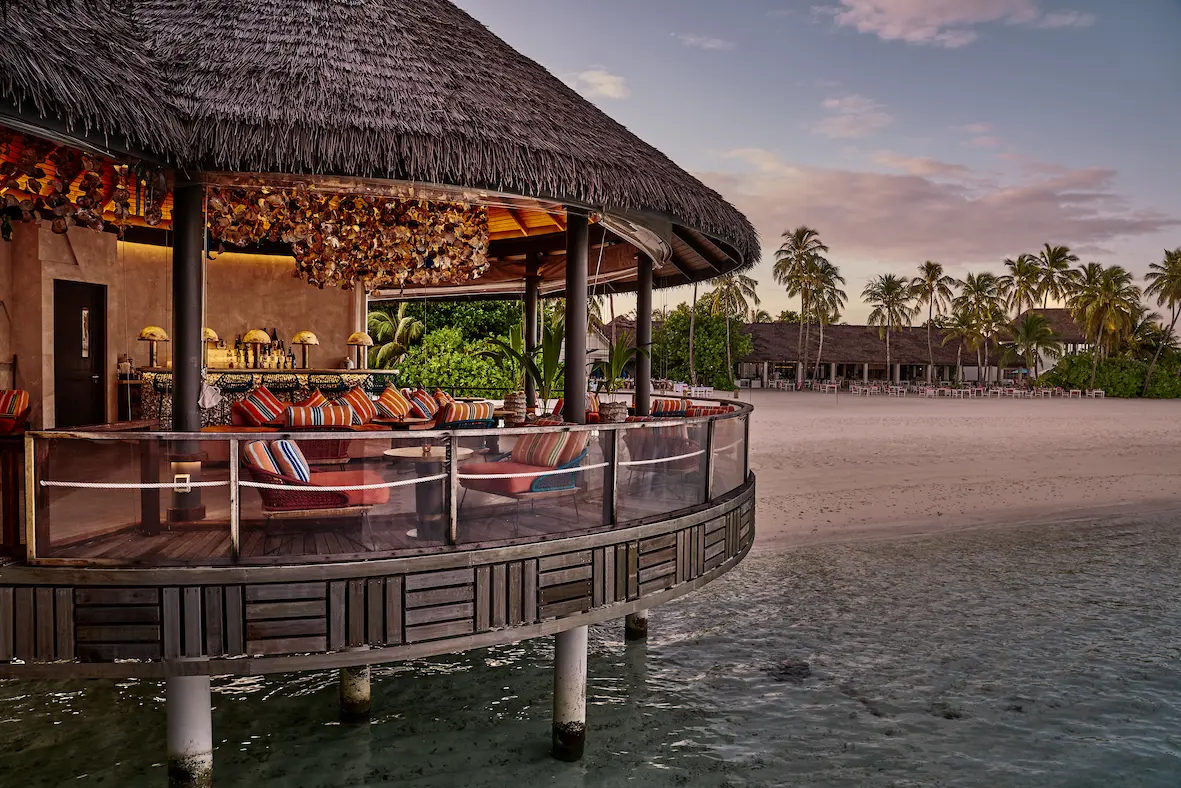 seaside finolhu maldives kanusan bar area elegant overwater bar setting with warm ambient lighting and refined island atmosphere