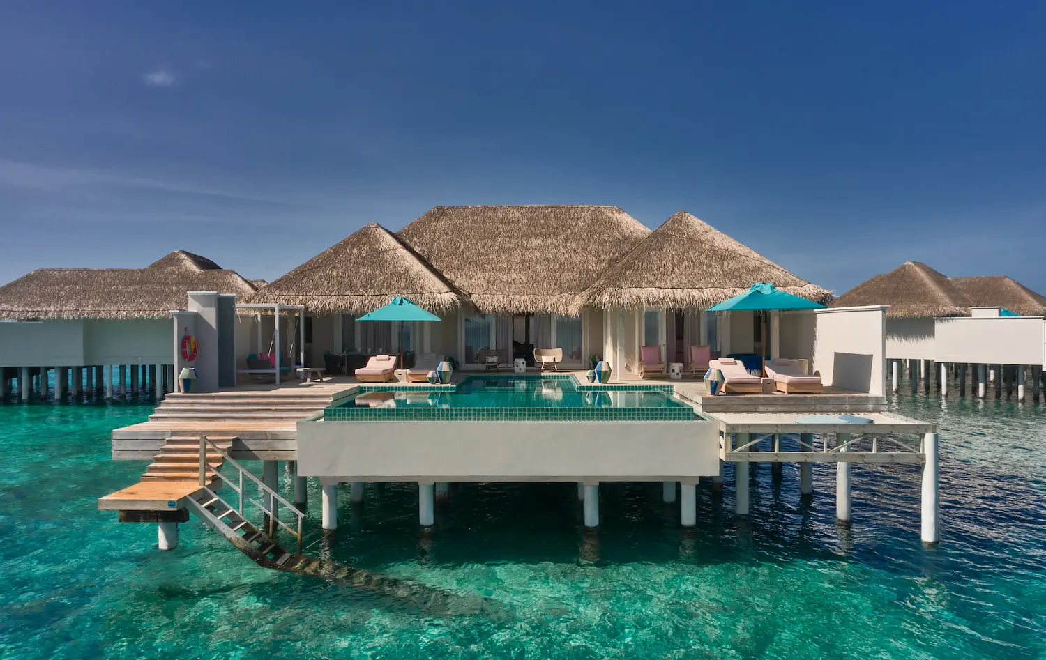 seaside finolhu maldives rockstar villa exterior view elegant beachfront facade with soft tropical light and serene ocean backdrop