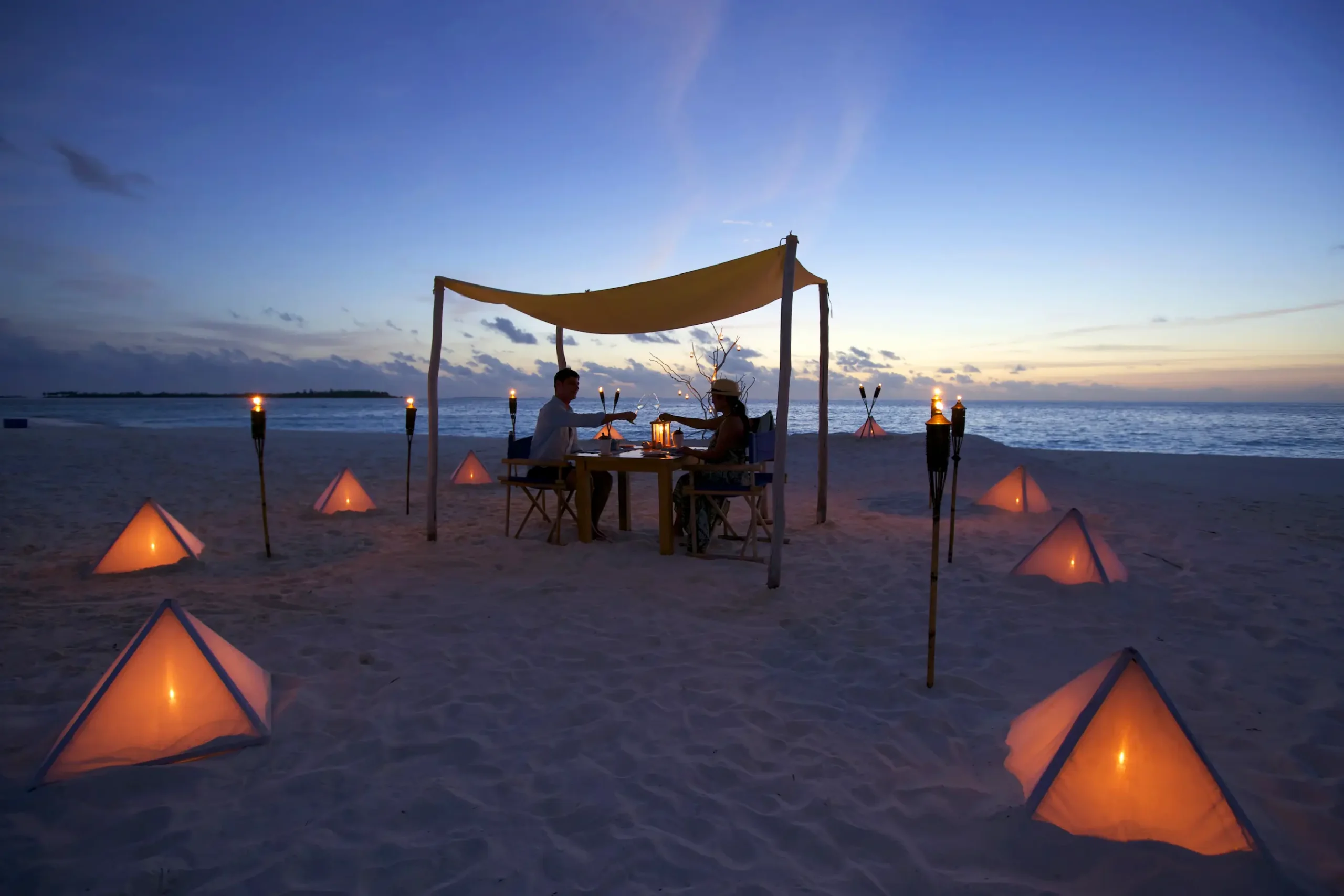 six senses laamu maldives destination dining set on a secluded beach with candlelit ambience ocean views and a serene elevated barefoot luxury atmosphere