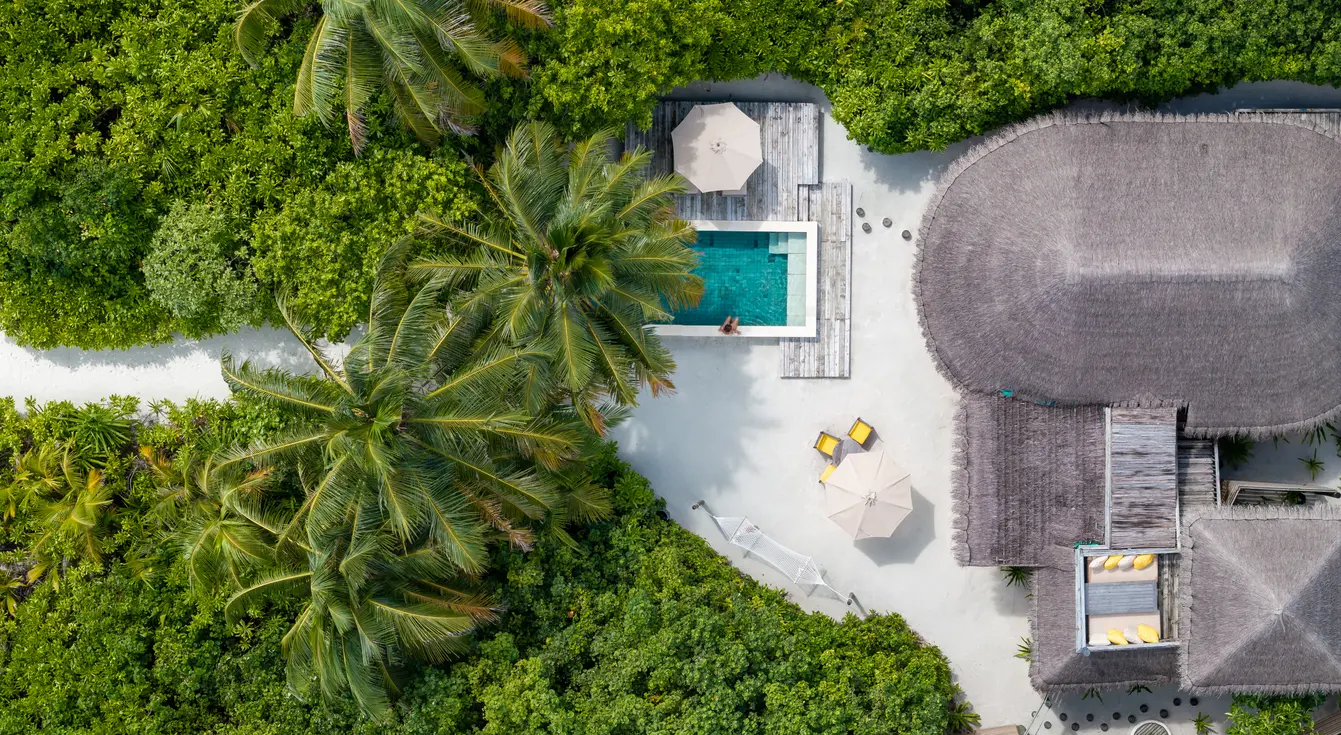 six senses laamu maldives family lagoon beach villa with pool aerial view overlooking turquoise lagoon tropical greenery and an elevated serene barefoot luxury atmosphere