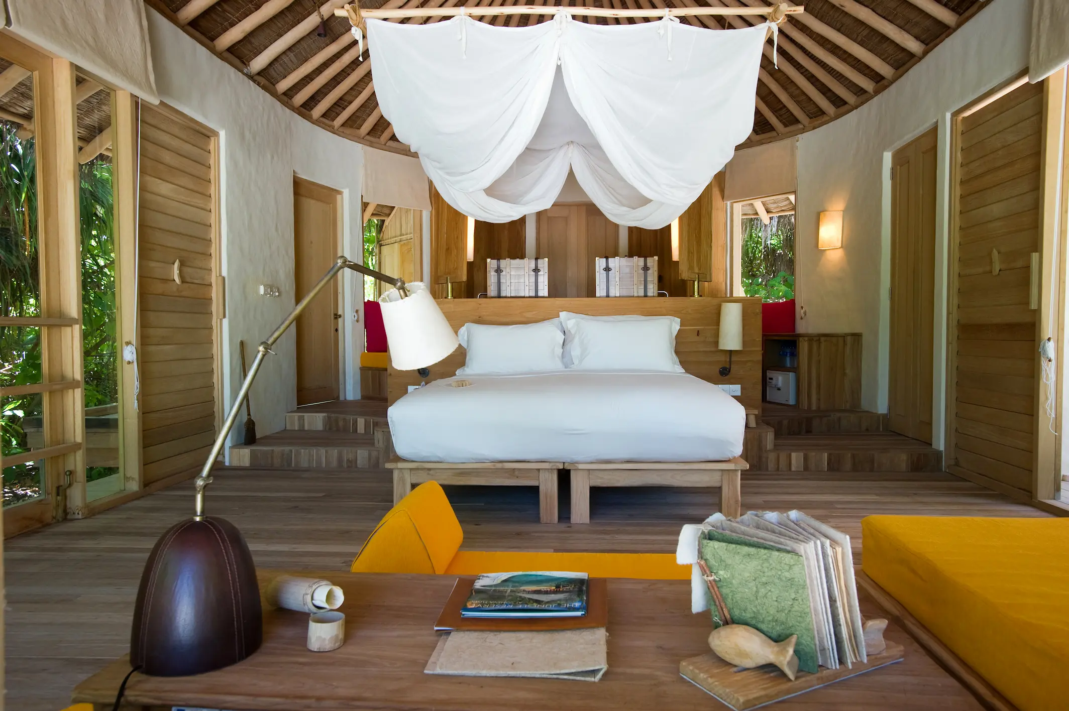six senses laamu maldives family lagoon beach villa with pool bedroom featuring natural wood textures soft warm lighting and a calm elevated barefoot luxury atmosphere