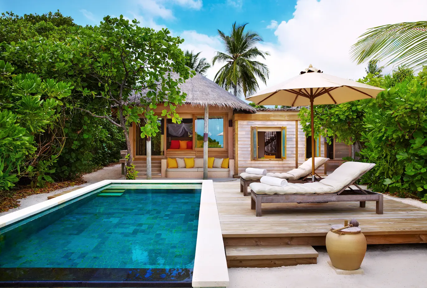 six senses laamu maldives family lagoon beach villa with pool exterior surrounded by tropical greenery natural wood architecture and a calm elevated barefoot luxury atmosphere