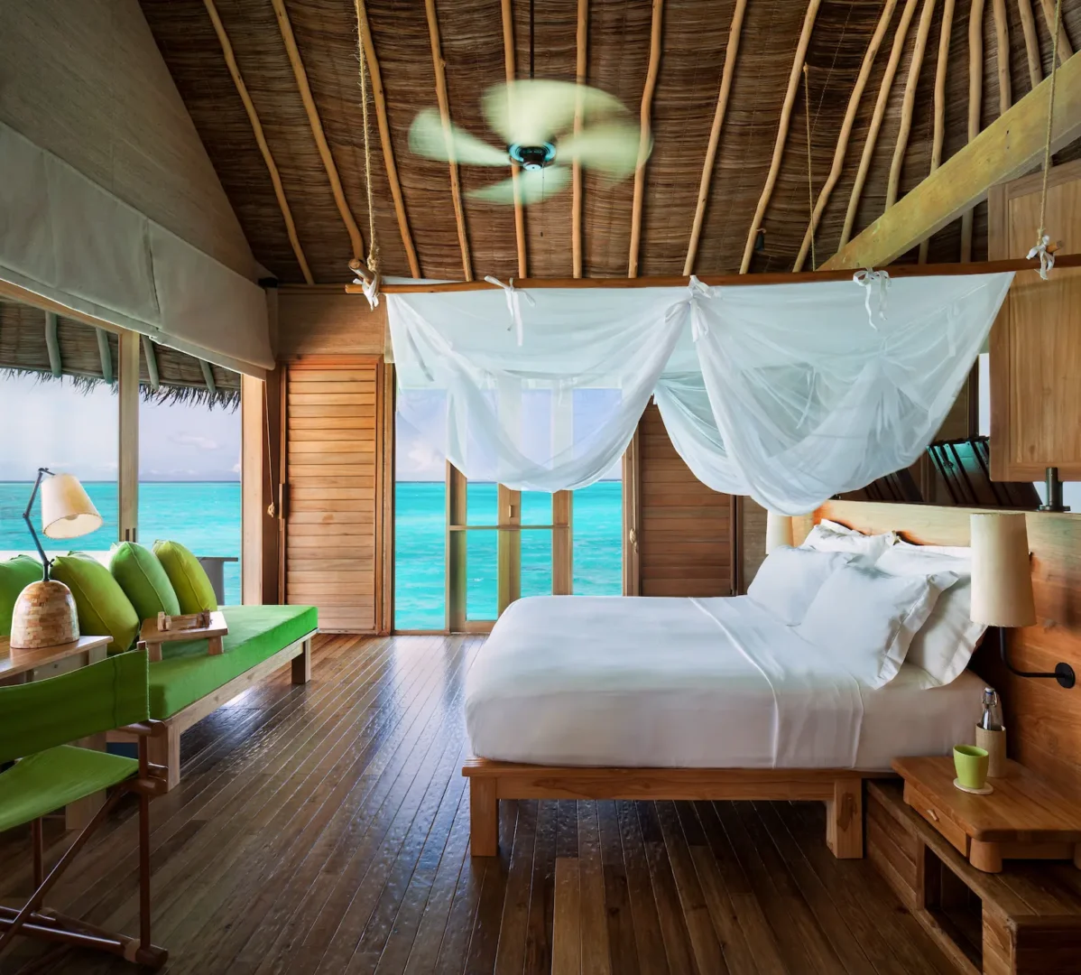 six senses laamu maldives laamu water villa with pool bedroom featuring calm lagoon views natural wood textures and an elevated refined barefoot luxury atmosphere