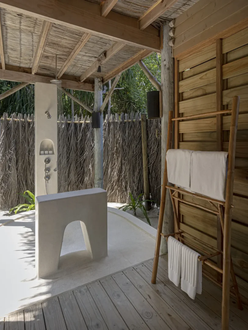 six senses laamu maldives lagoon beach villa with pool bathroom featuring natural textures soft ambient lighting and a serene elevated barefoot luxury atmosphere