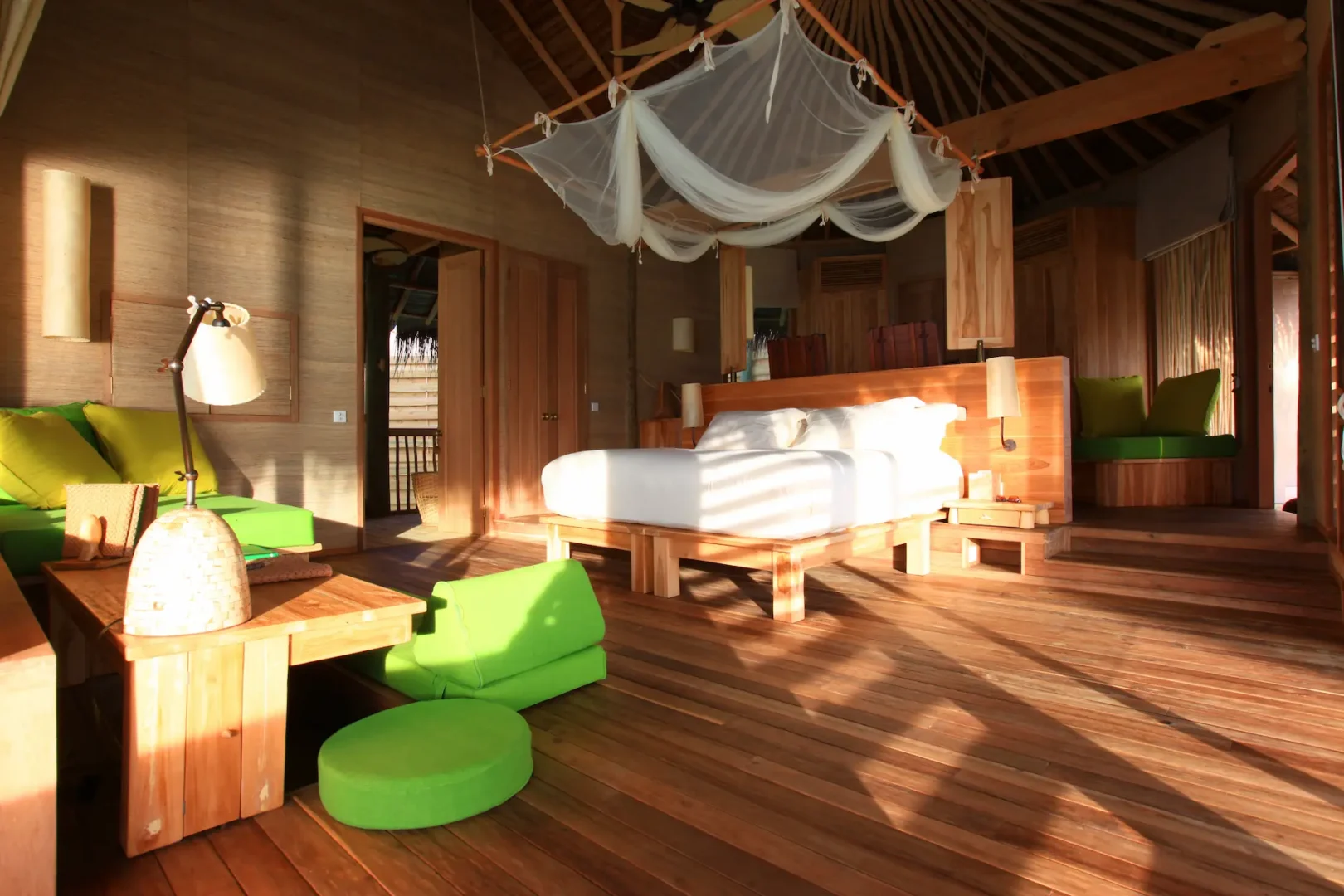 six senses laamu maldives lagoon water villa bedroom with serene ocean views natural wood textures and elevated barefoot luxury ambience