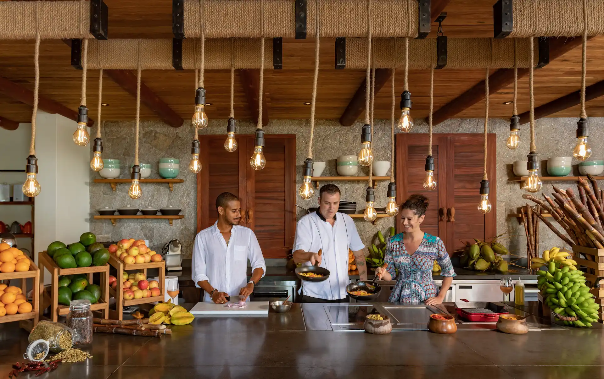 cooking class in chefs kitchen at six senses seychelles with chef demonstrating and participants cooking