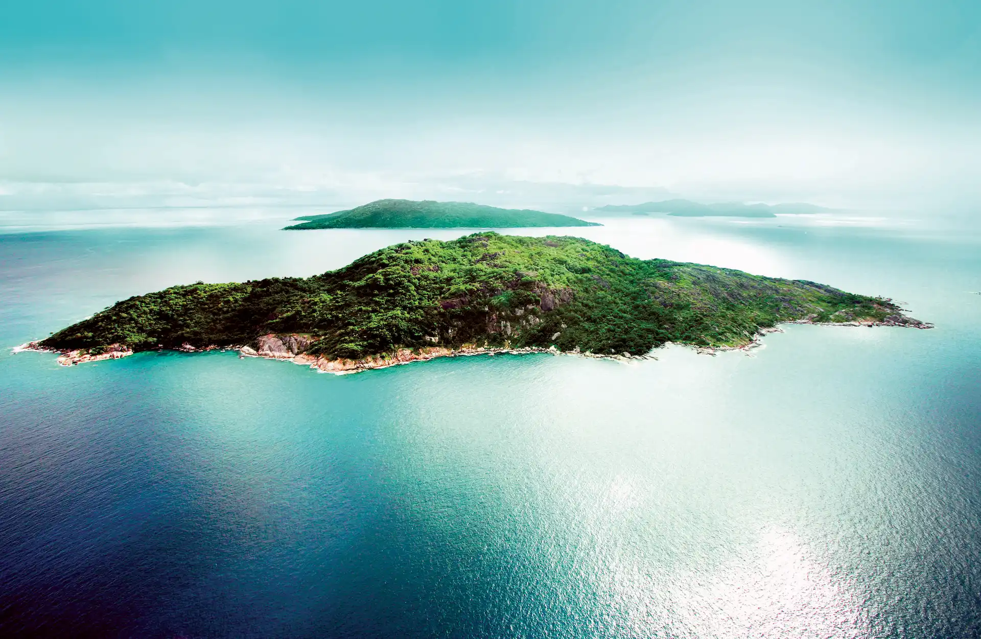 aerial view of felicite island near six senses seychelles with villas, ocean, and surrounding small islands