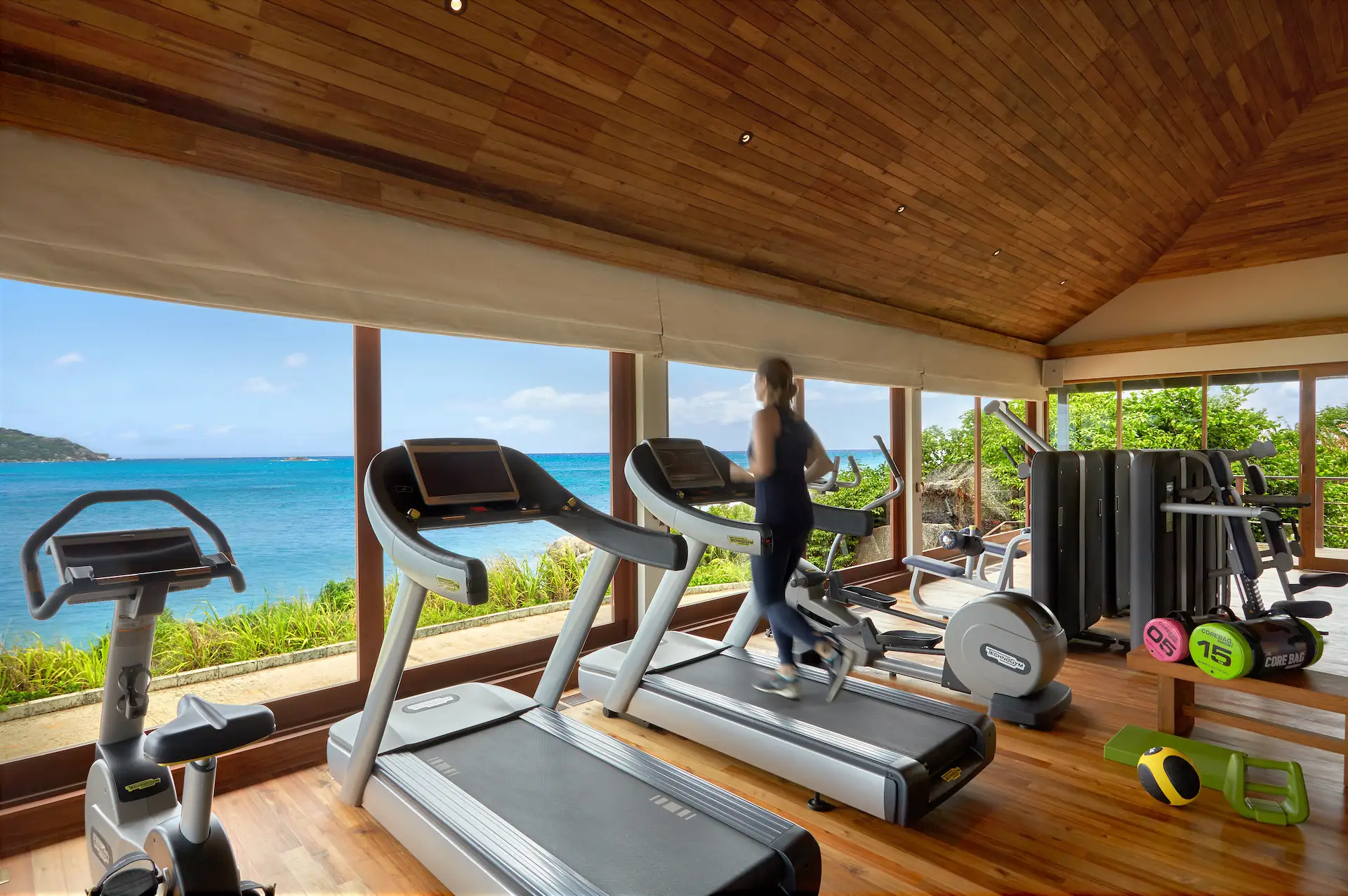 gym at six senses seychelles with exercise equipment and ocean view through large windows