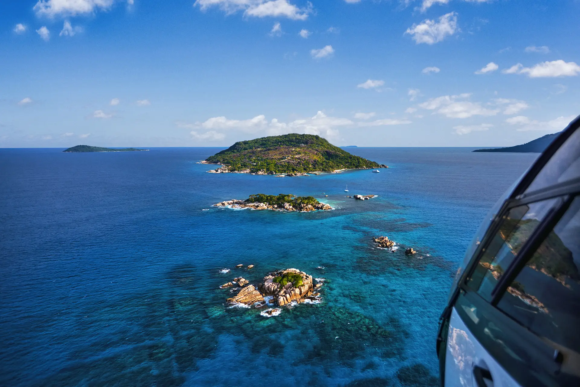helicopter at six senses seychelles ready for takeoff with ocean and island views