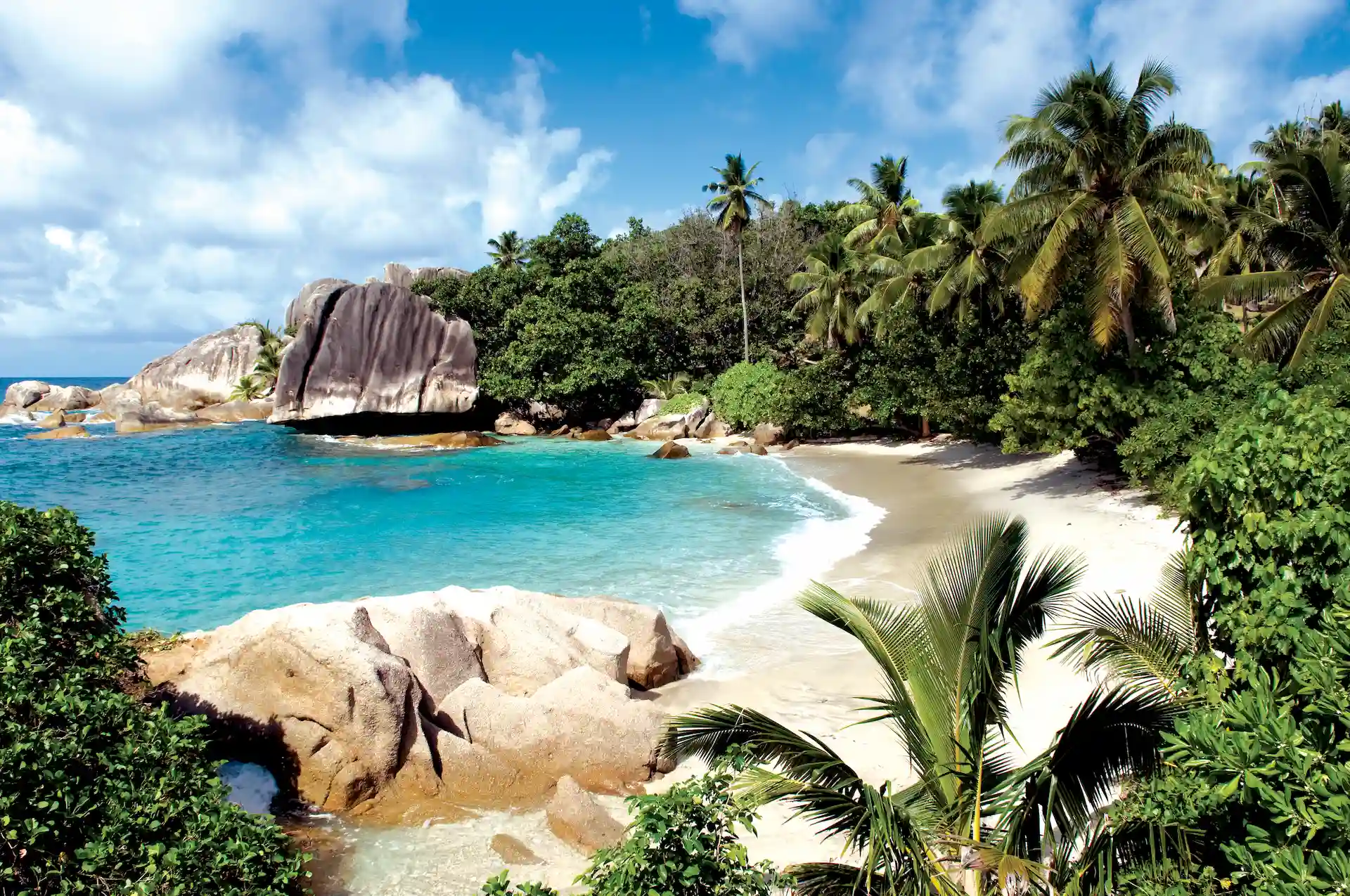 beach at six senses seychelles with white sand and clear blue ocean