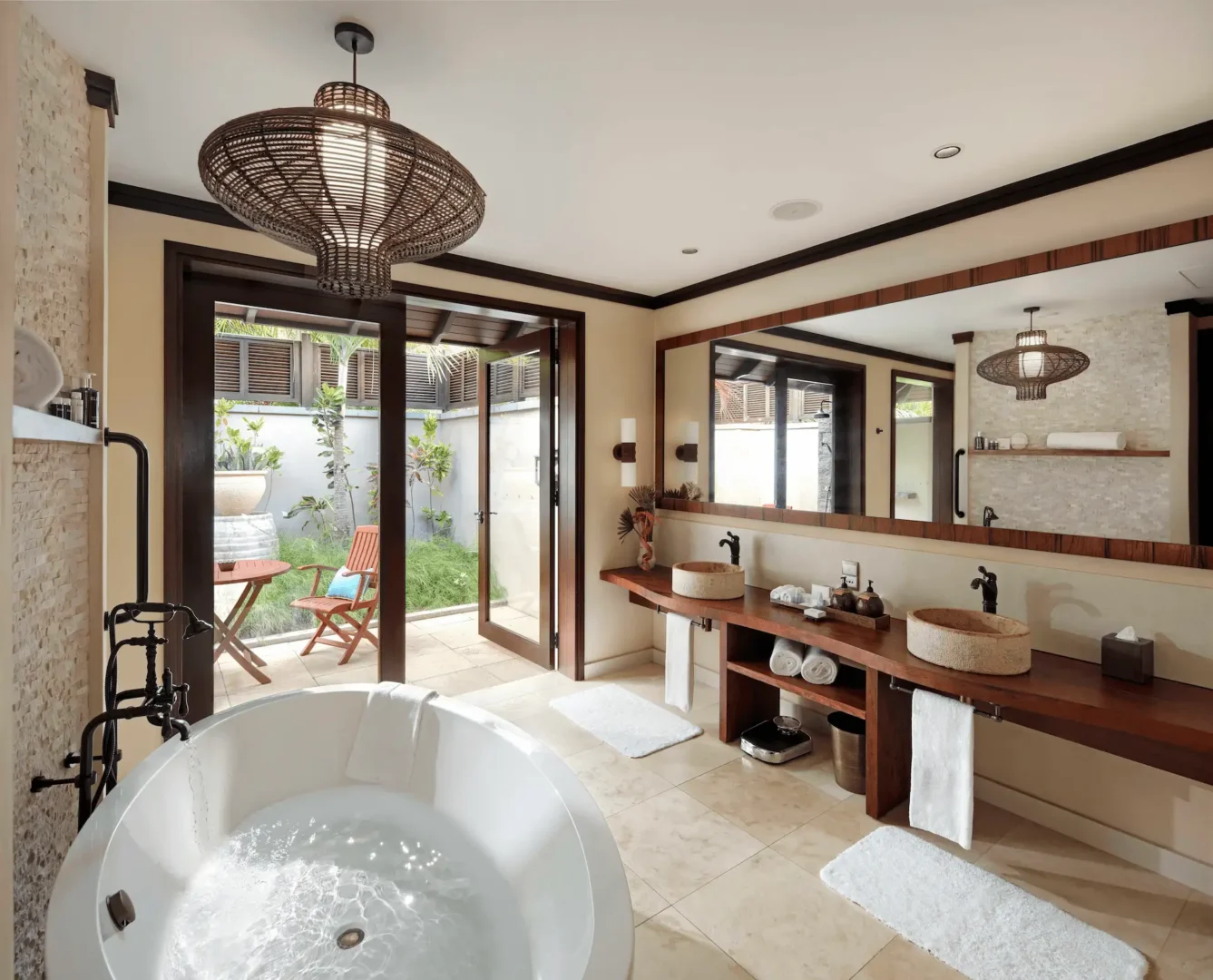 Bathroom of a beach pool villa in Seychelles, featuring a modern bathtub, shower, and elegant tropical-inspired decor