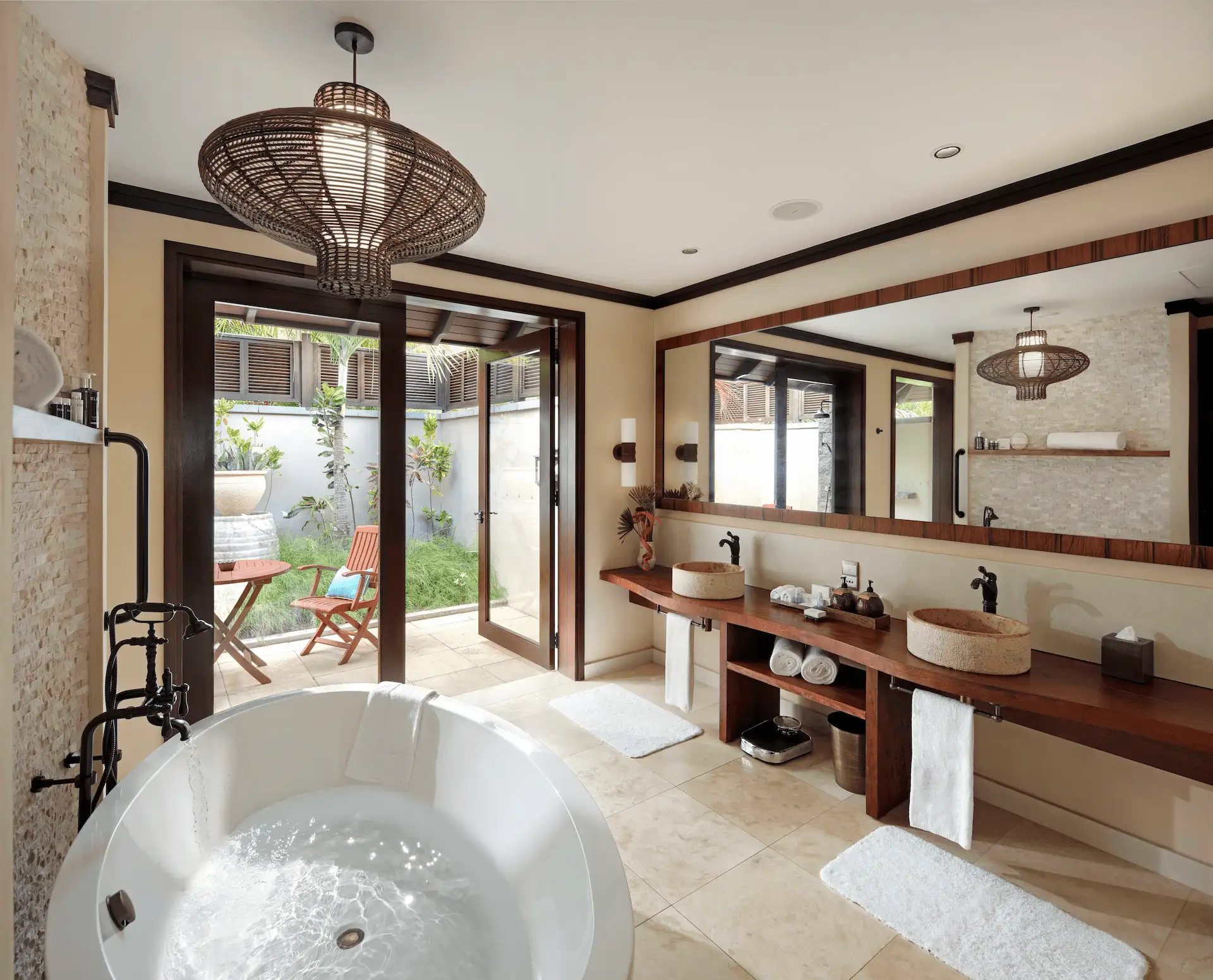 Bathroom of a beach pool villa in Seychelles, featuring a modern bathtub, shower, and elegant tropical-inspired decor