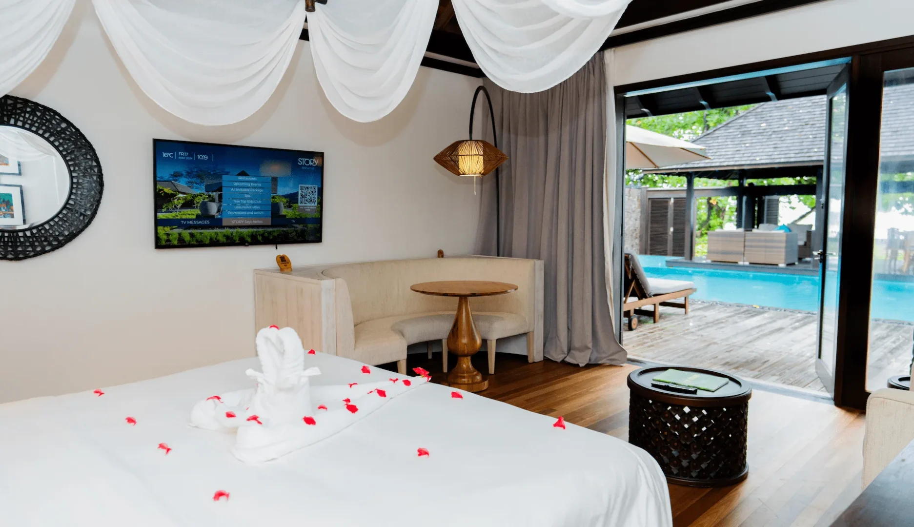 view from the bed in a grand beach pool villa in Seychelles looking out toward the private pool and outdoor area