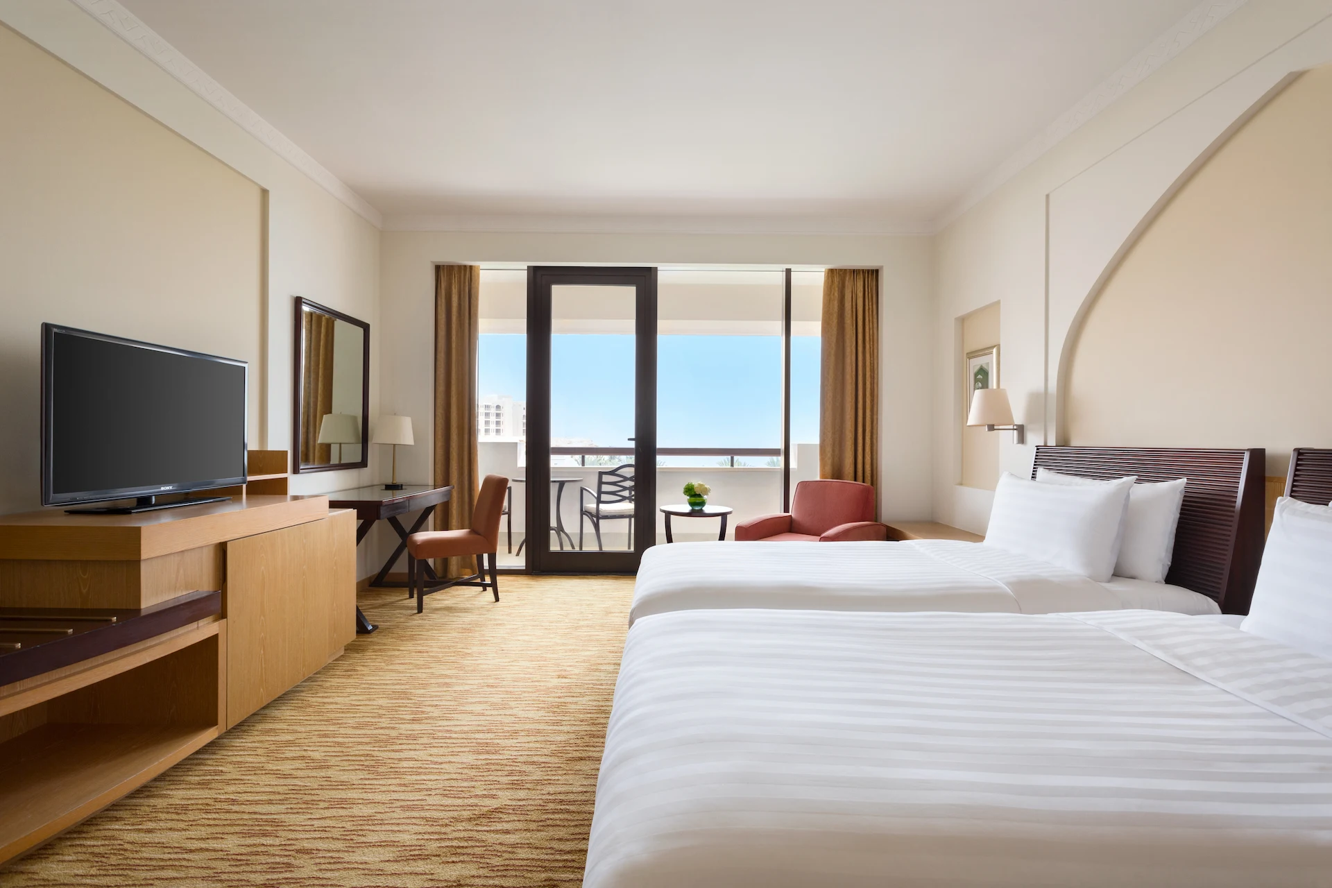 twin bed guest room with sea view at hilton muscat al bandar oman resort