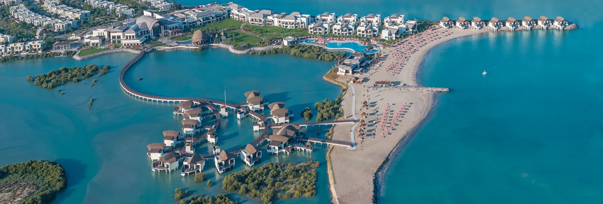 anantara mina ras al khaimah full aerial view showcasing the complete resort layout set between the beachfront and surrounding natural landscape