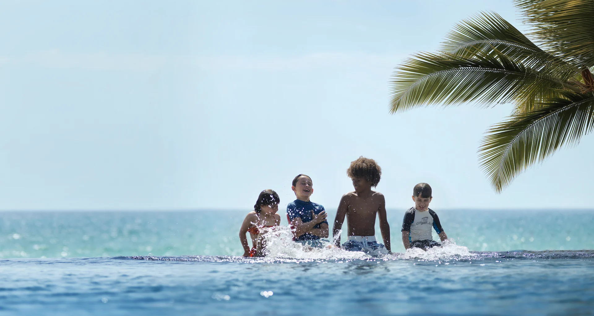 children playing in infinity pool at al baleed resort salalah by anantara oman