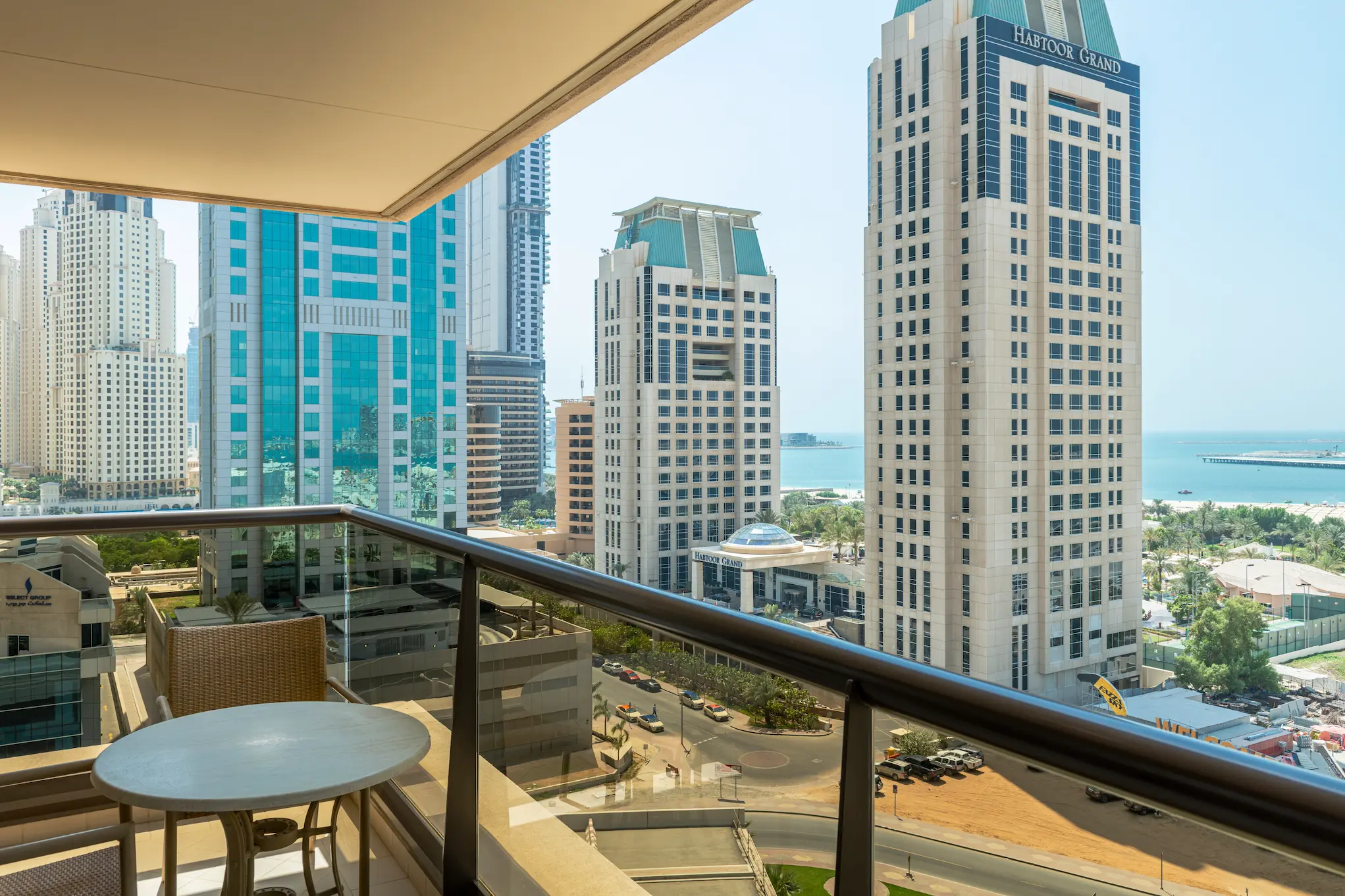 grosvenor house dubai premier room king bed city view balcony overlooking the dynamic urban skyline