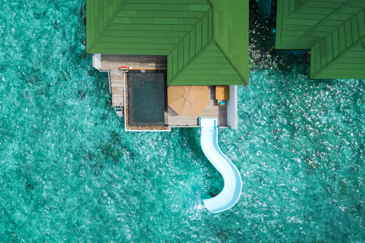 siyam world maldives ocean villa with pool slide aerial view showcasing elevated overwater luxury
