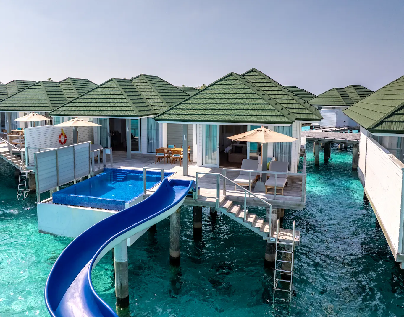 siyam world maldives two bedroom lagoon villa with pool slide exterior showcasing elevated overwater luxury