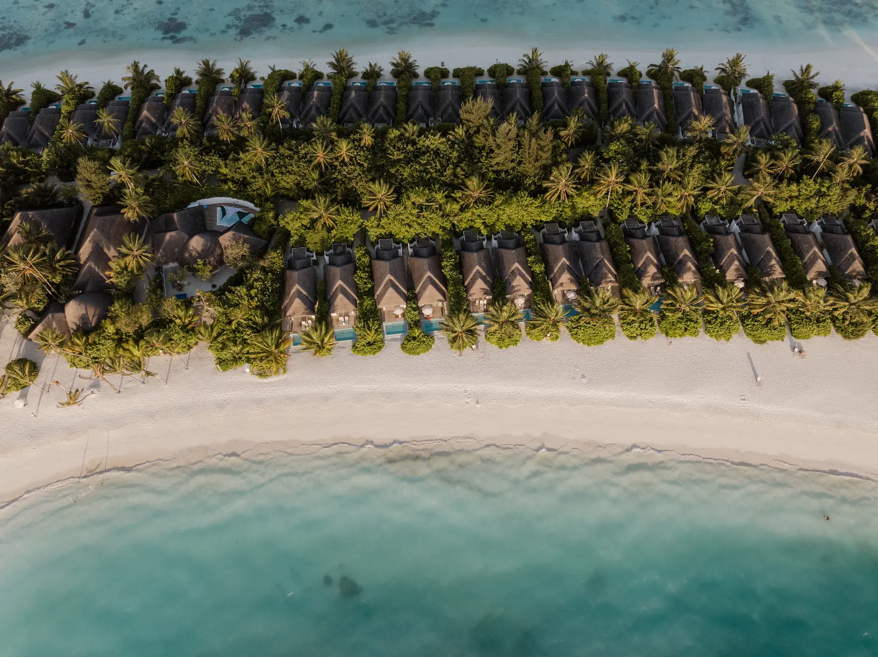 sun siyam iru veli maldives aerial beach villa nestled along white sand shoreline with lush tropical surroundings