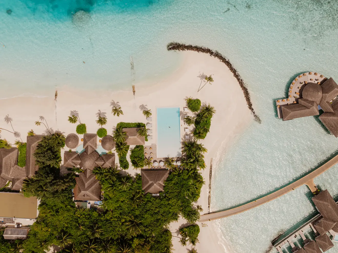 sun siyam iru veli maldives aerial pool surrounded by turquoise lagoon and white sand shoreline