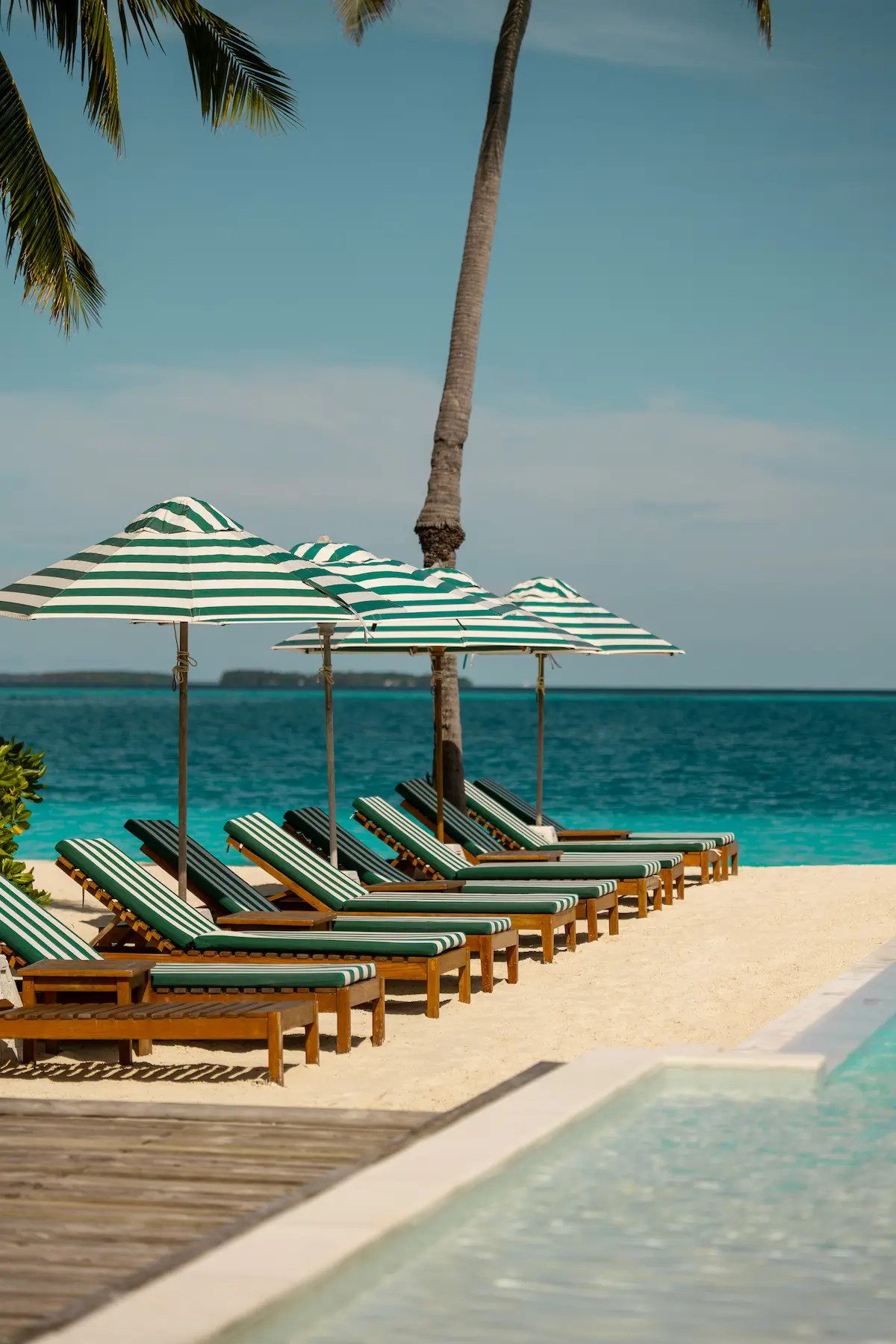 sun siyam iru veli maldives sun beds set along the beach overlooking clear turquoise waters