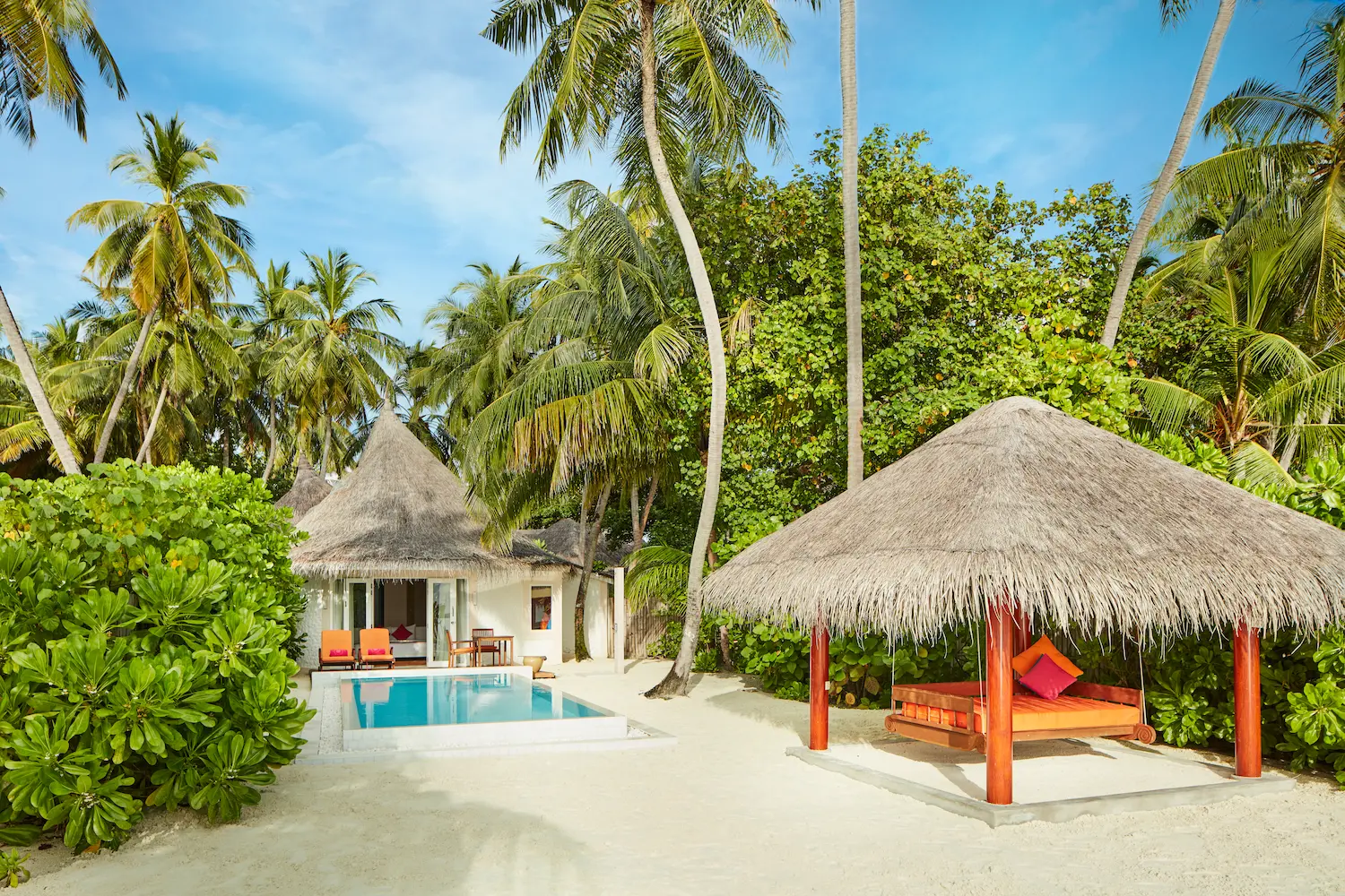 sun siyam vilu reef maldives beach villa with pool daybed set within a private outdoor space overlooking lush tropical surroundings