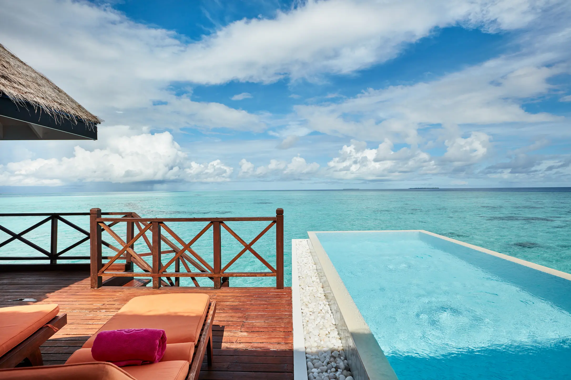 sun siyam vilu reef maldives grand water villa with pool view overlooking the turquoise lagoon and expansive ocean horizon