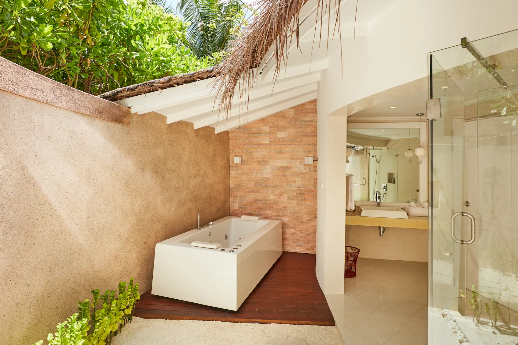 sun siyam vilu reef maldives jacuzzi deluxe beach villa bathroom featuring elegant finishes and a serene tropical atmosphere
