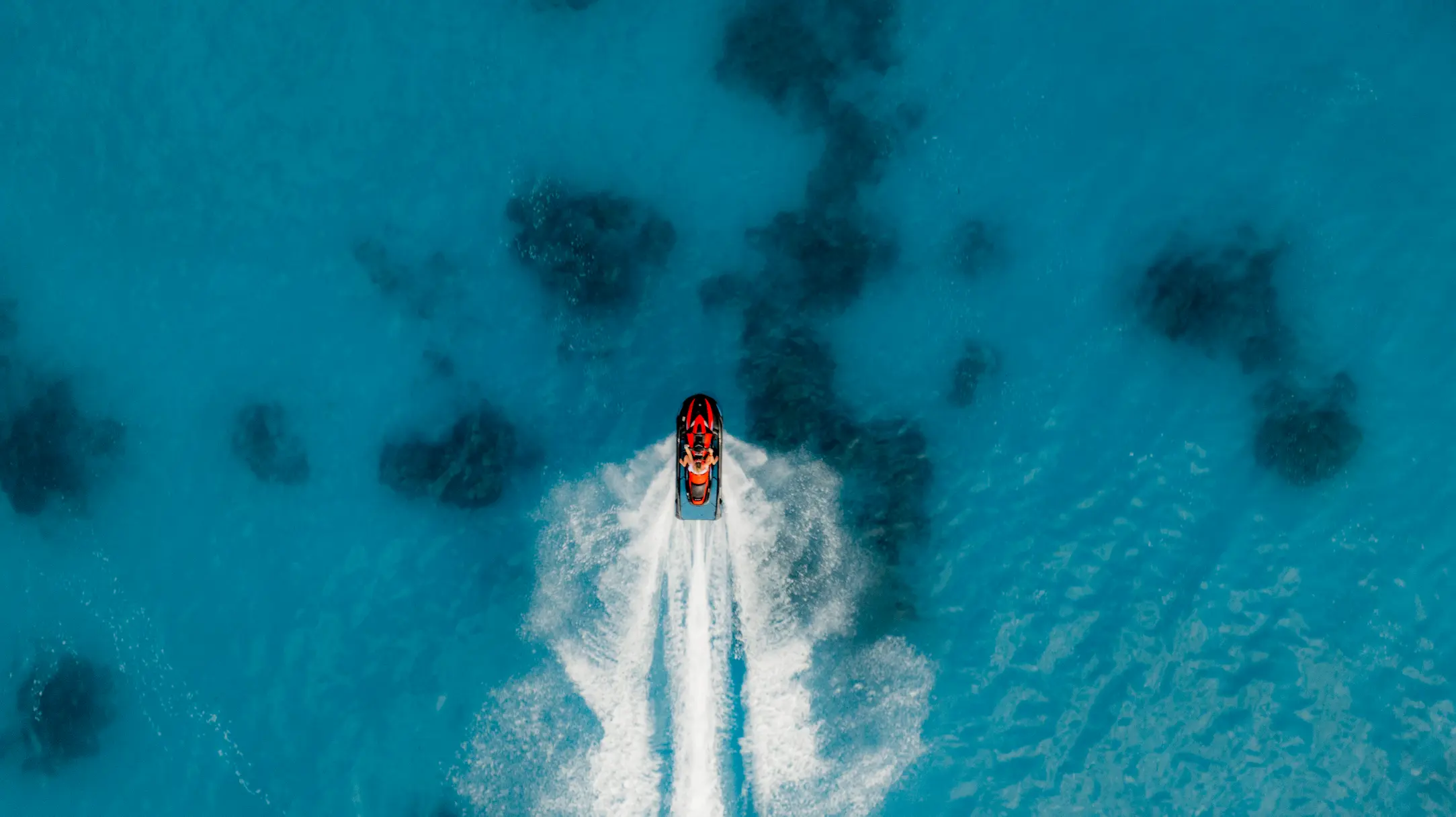 sun siyam vilu reef maldives jet ski experience across clear turquoise waters in a vibrant ocean setting