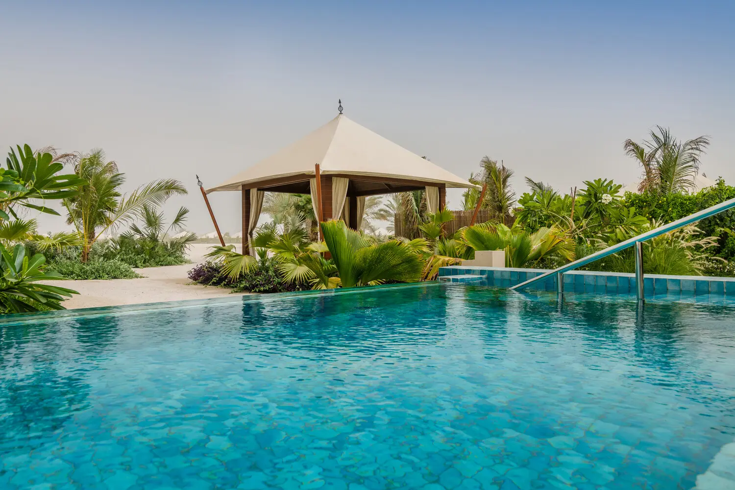 the ritzcarlton al hamra beach al naseem tented villa pool beach showcasing a private pool opening directly onto the natural beachfront setting