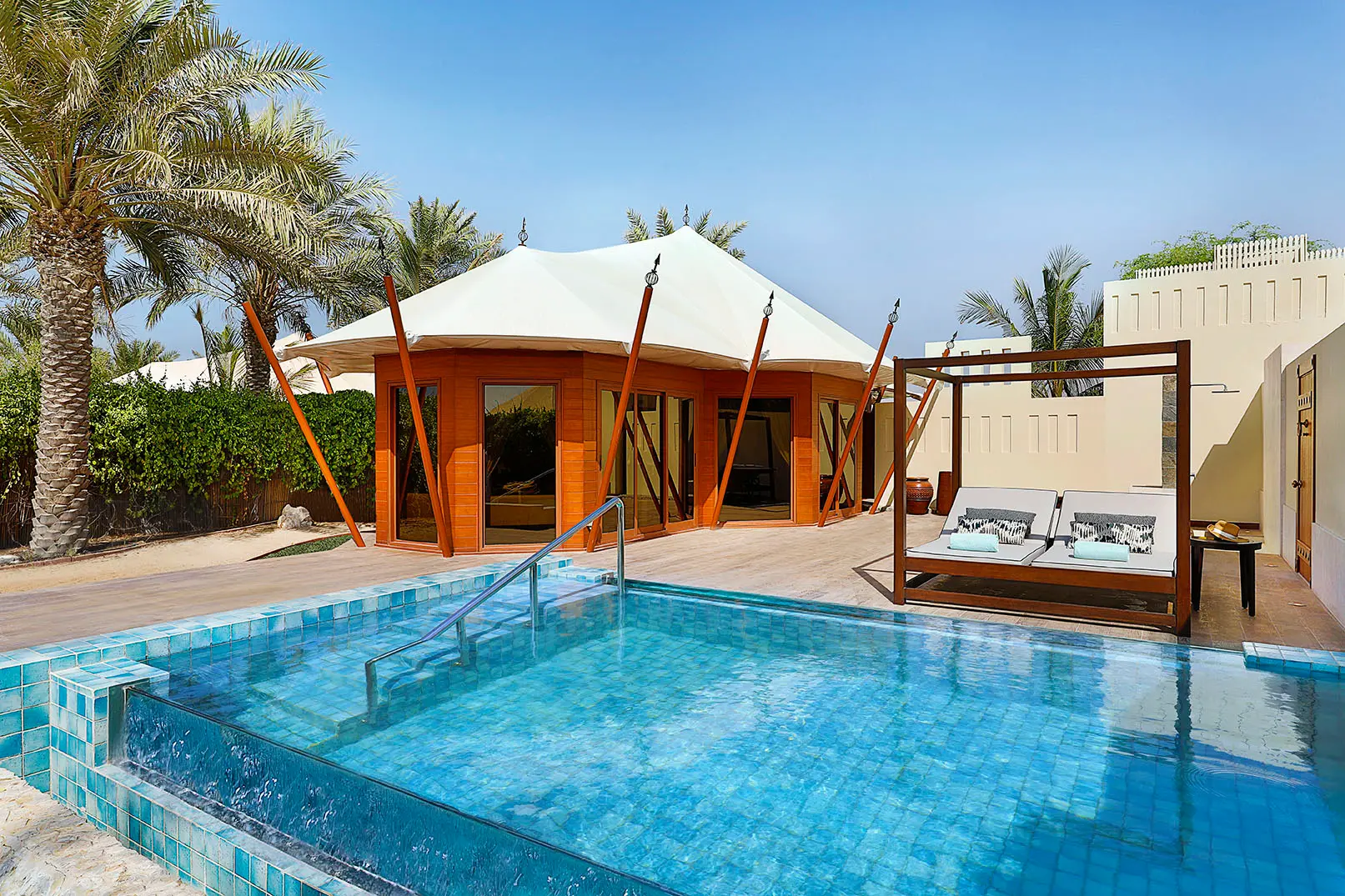 the ritzcarlton al hamra beach al nassem tented villa exterior showcasing a secluded beachfront villa set within a natural coastal setting