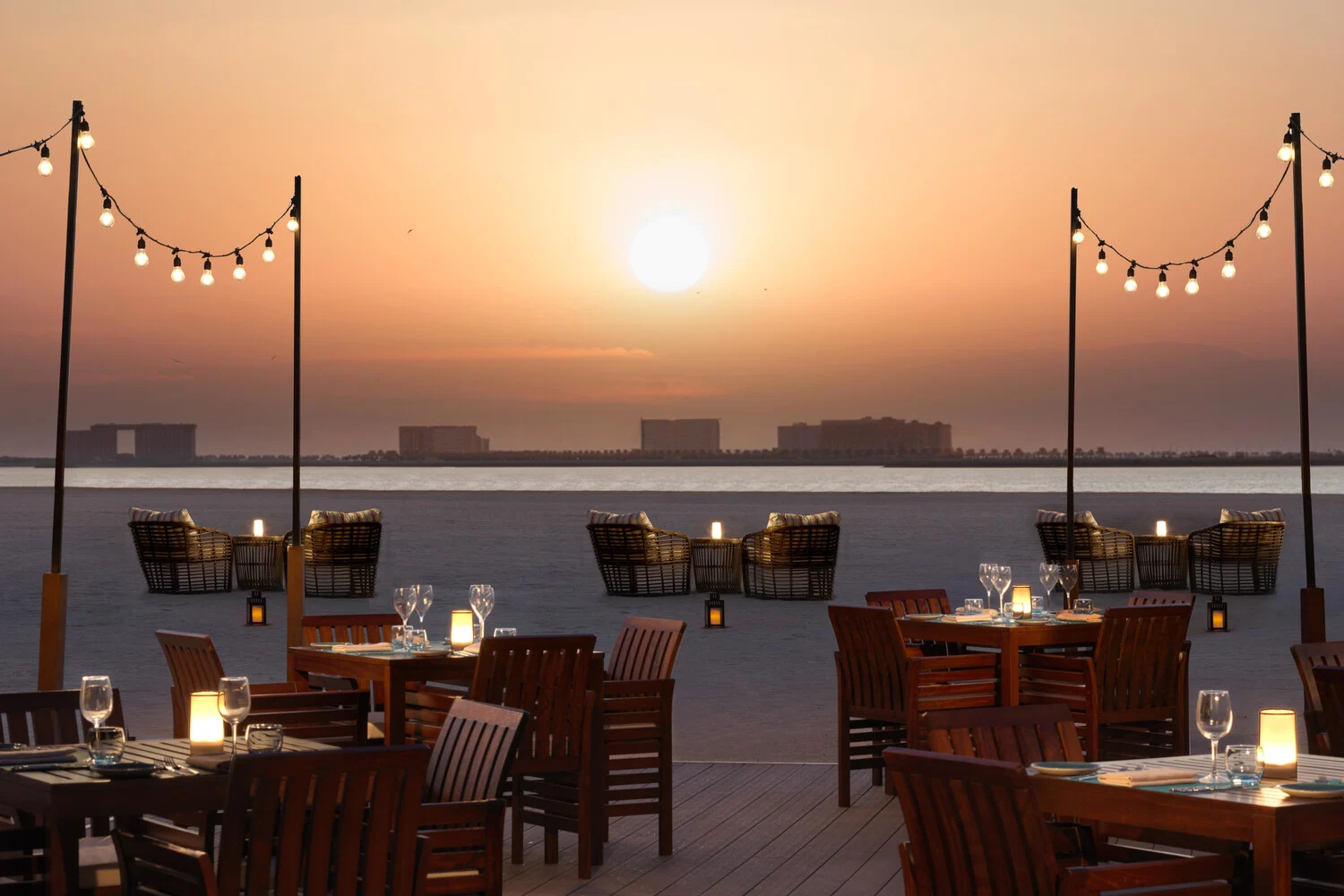 the ritzcarlton al hamra beach beach deck at sunset showcasing warm coastal tones and ocean views at golden hour
