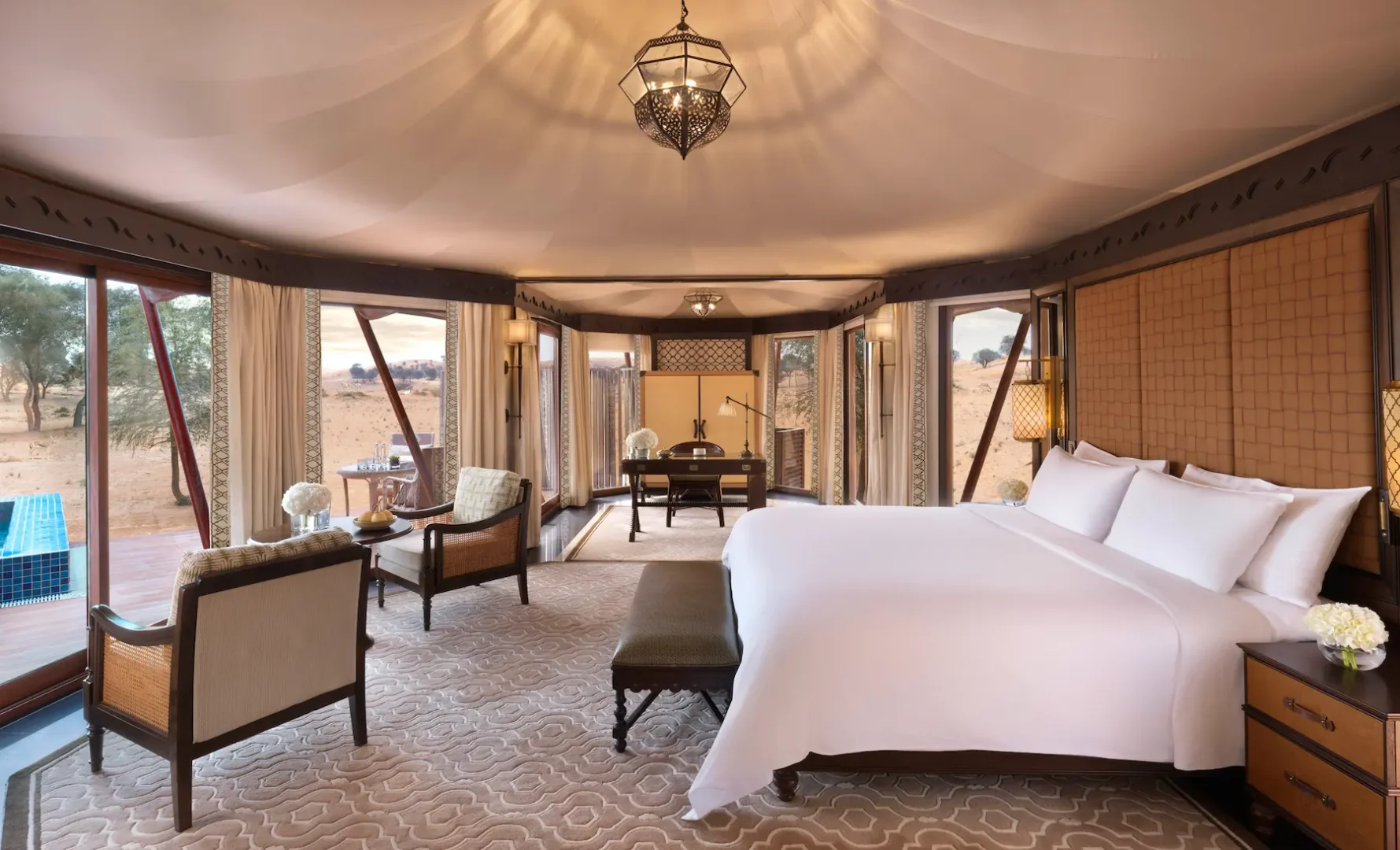the ritzcarlton al wadi desert al khaimah villa bedroom with an elegant bed and refined desert inspired interiors