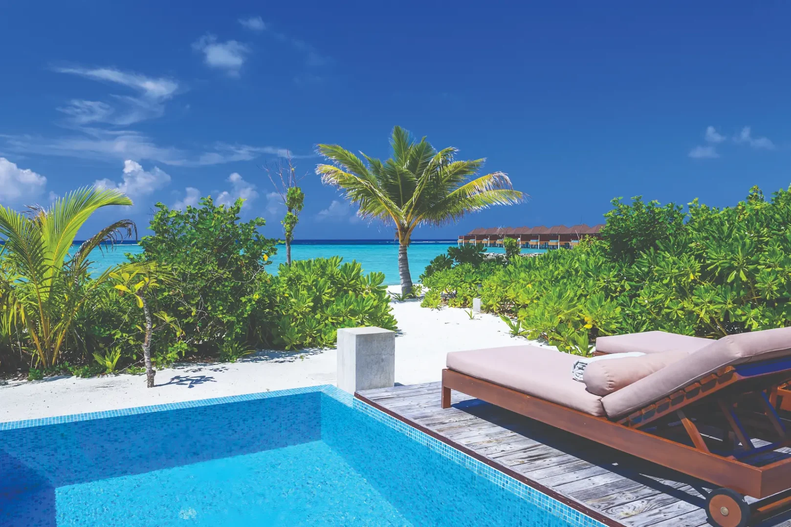 luxury beach villa with private pool deck view featuring sunbeds at varu by atmosphere maldives