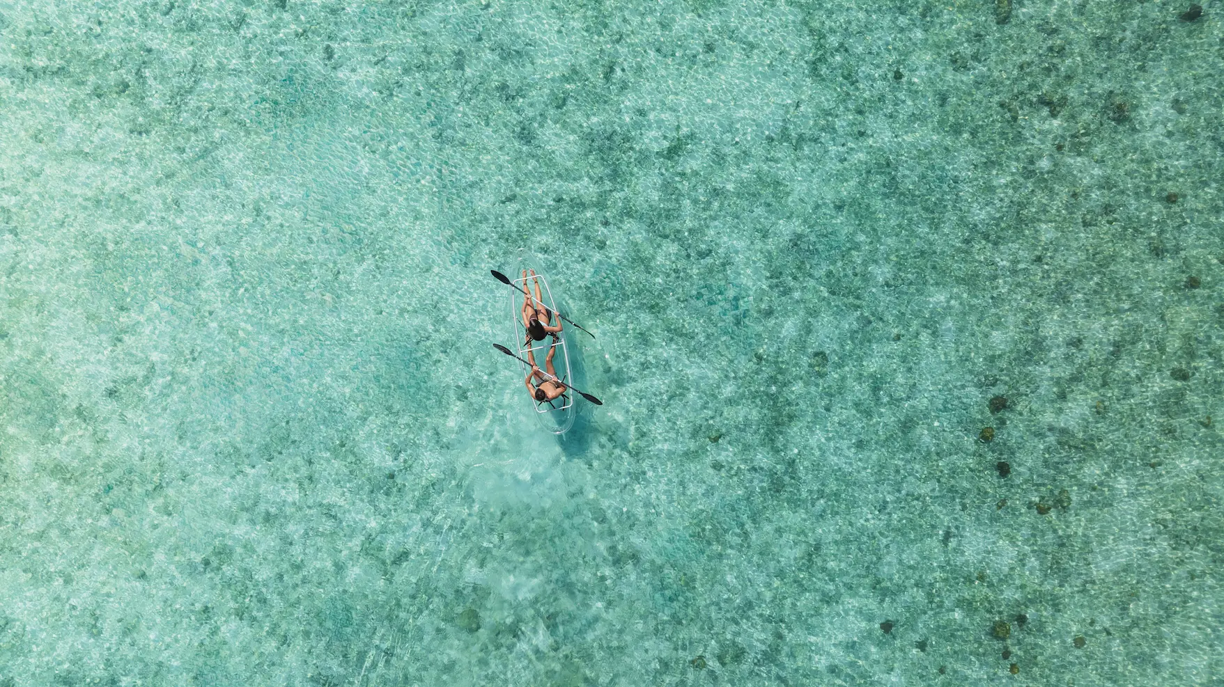 canoe watersports experience at varu by atmosphere maldives across calm turquoise lagoon