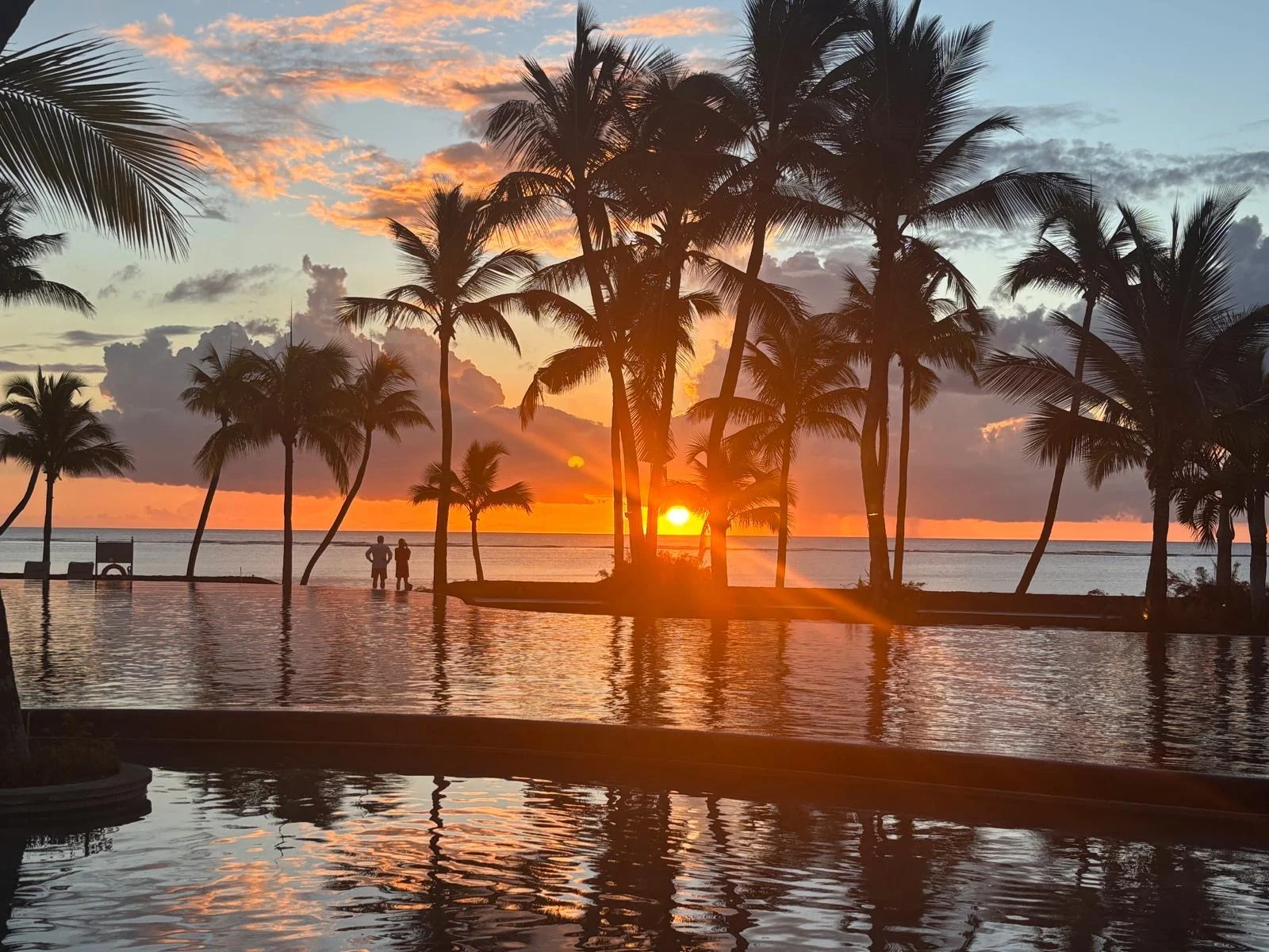 beachcomber resorts sunset over tropical beachfront with golden hour light and calm ocean horizon