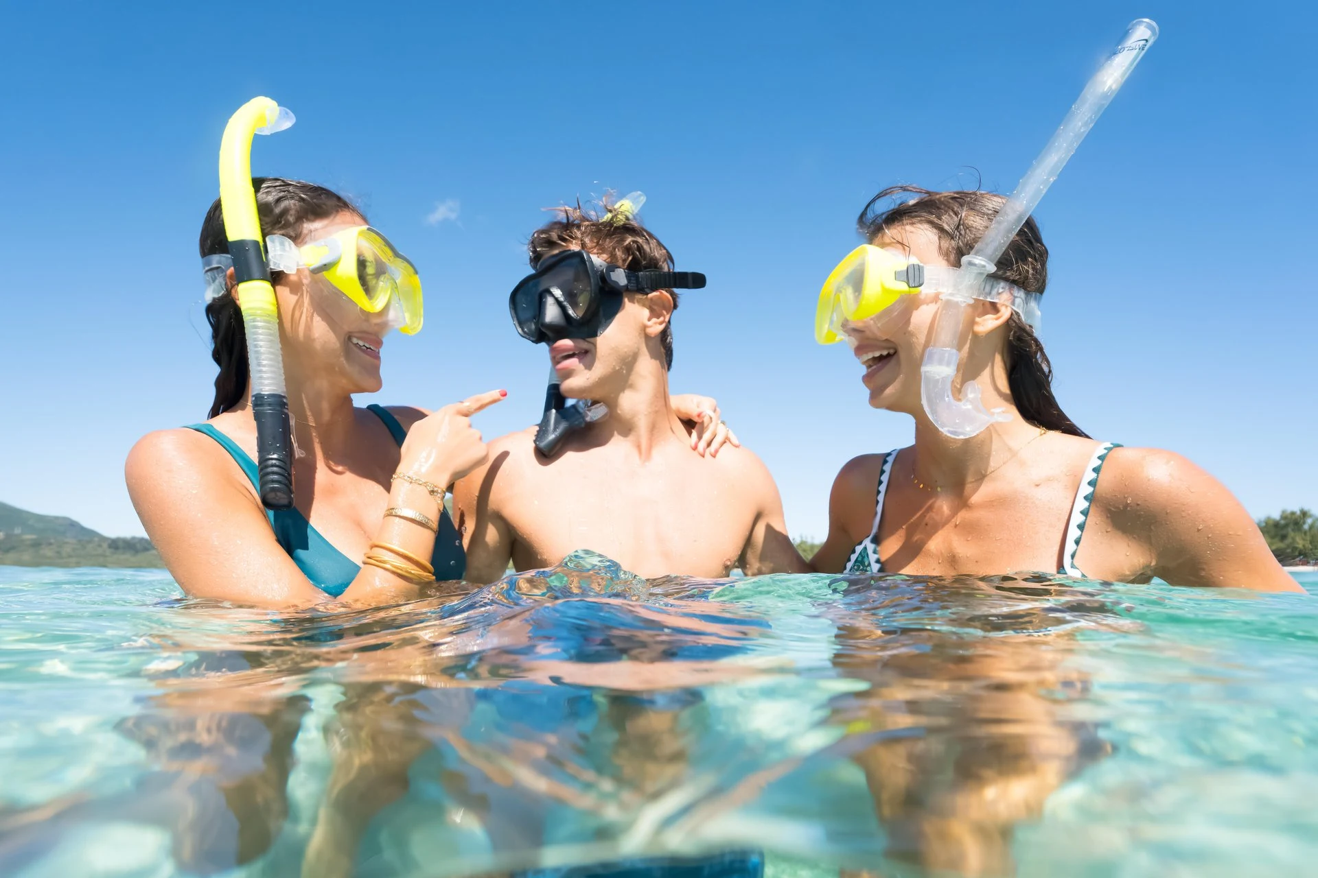 family snorkelling together in clear turquoise waters in mauritius exploring coral reef and marine life