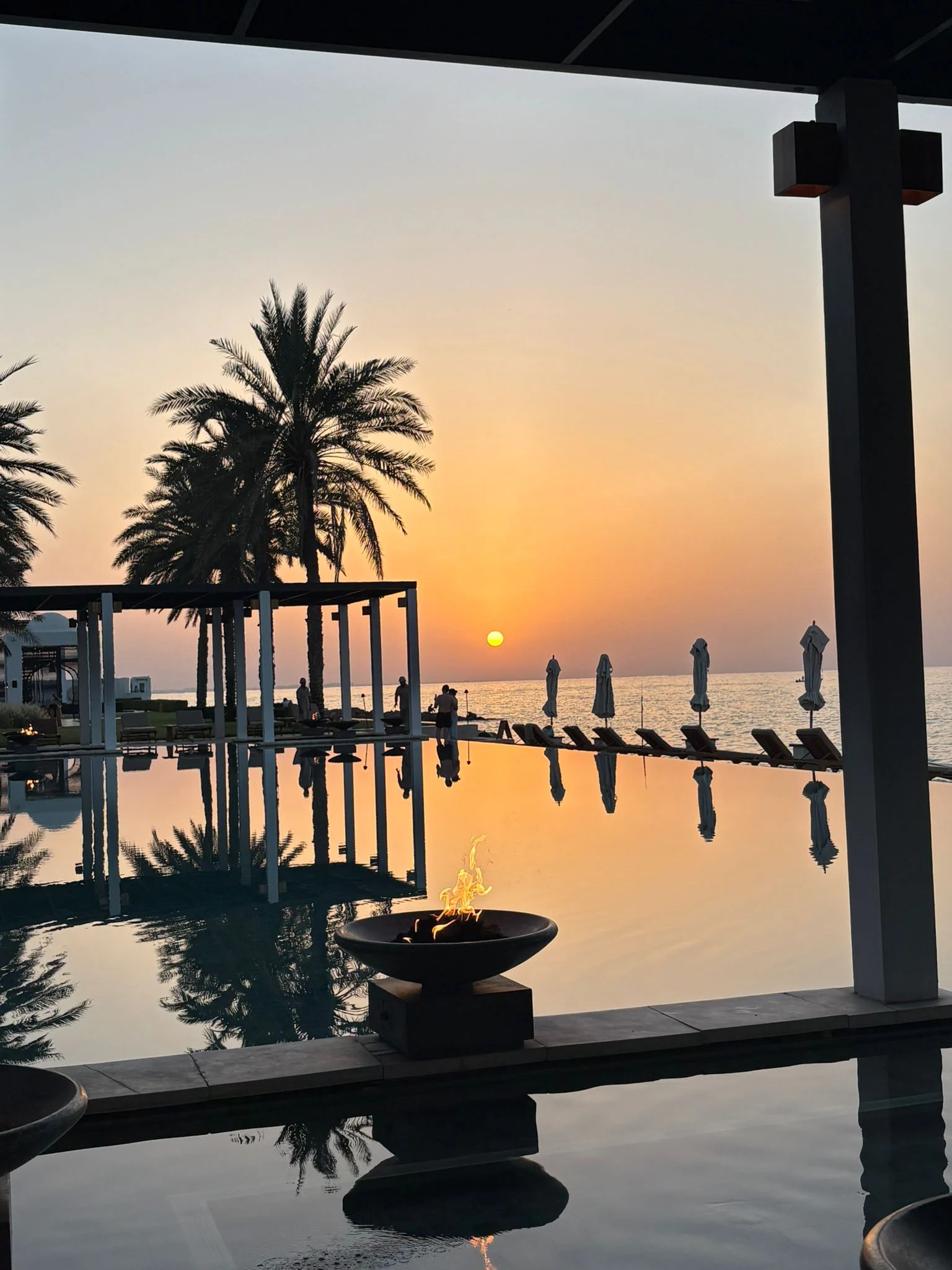 the chedi muscat sunset over luxury resort with warm golden hour light and tranquil atmosphere