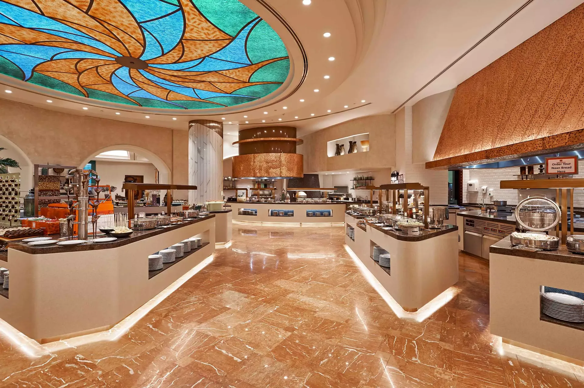 atlantis the palm kaleidoscope interior buffet stations featuring a vibrant selection of international cuisine with live cooking displays in a lively luxury dining setting in dubai