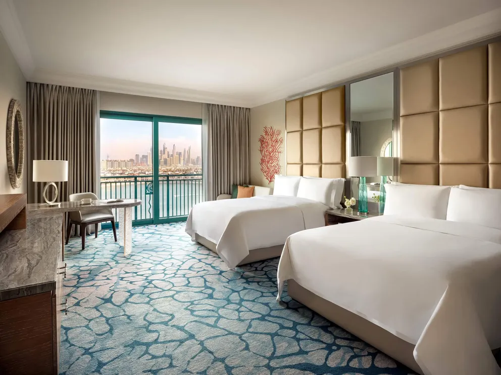 atlantis the palm palm view room with queen beds featuring elegant interiors, soft neutral tones and sweeping views across dubai skyline