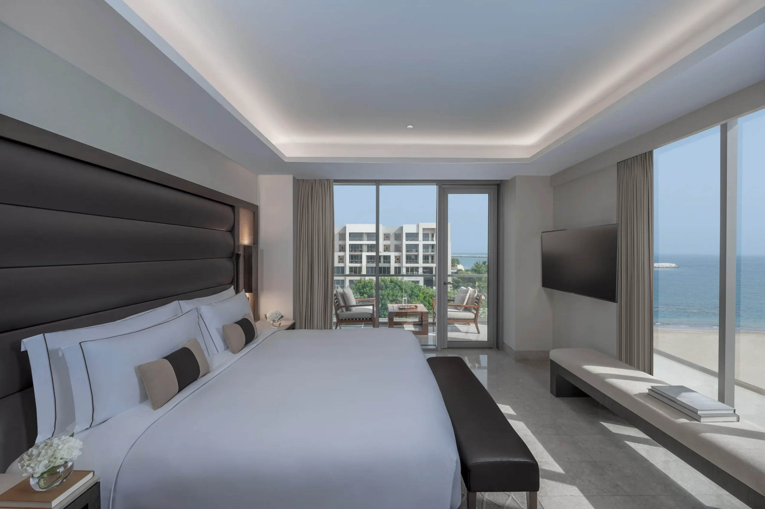 kempinski hotel muscat muscat deluxe sea view suite bedroom with luxurious furnishings and stunning sea views