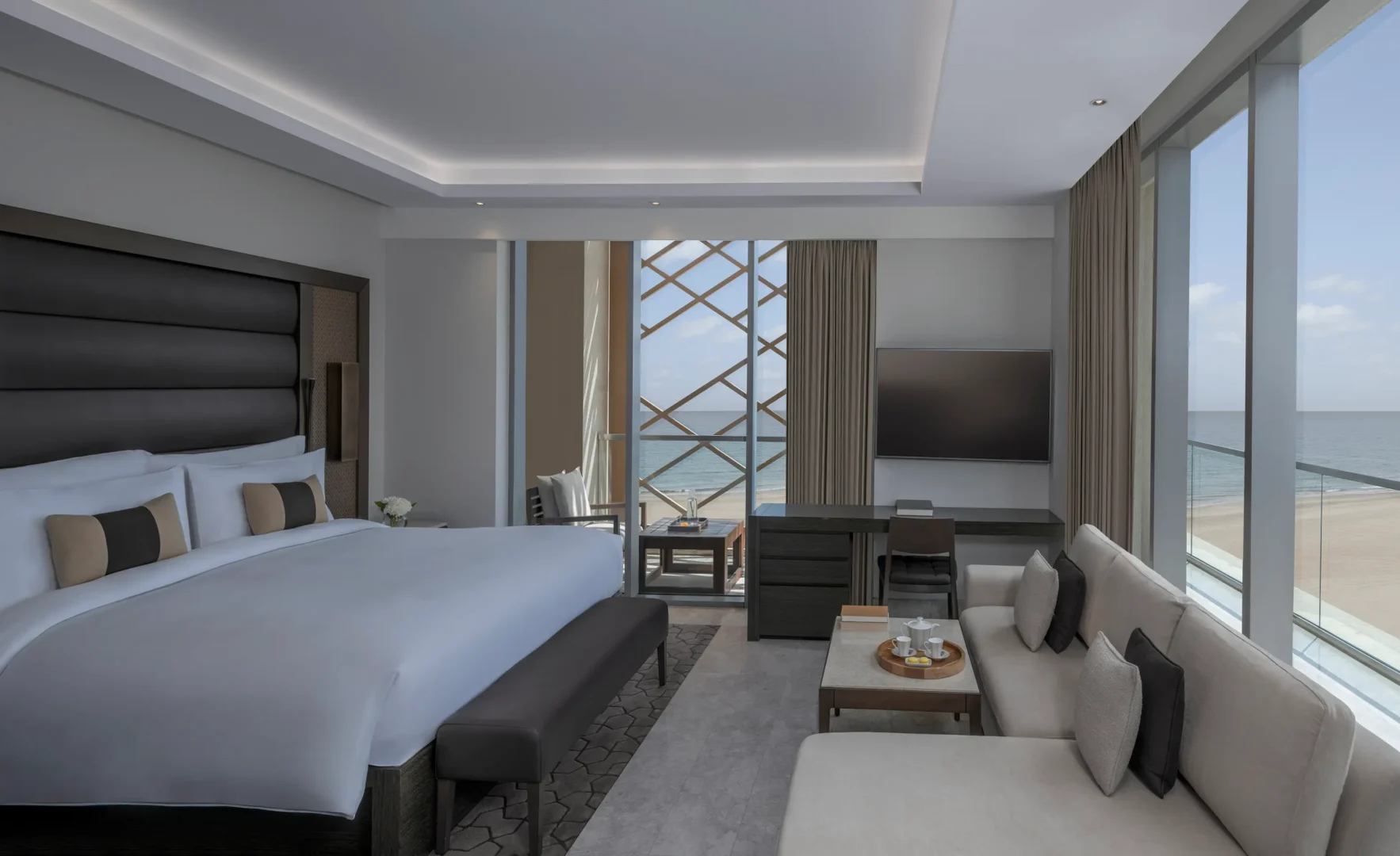 kempinski hotel muscat muscat grand deluxe sea view room bedroom with elegant furnishings and sweeping sea views