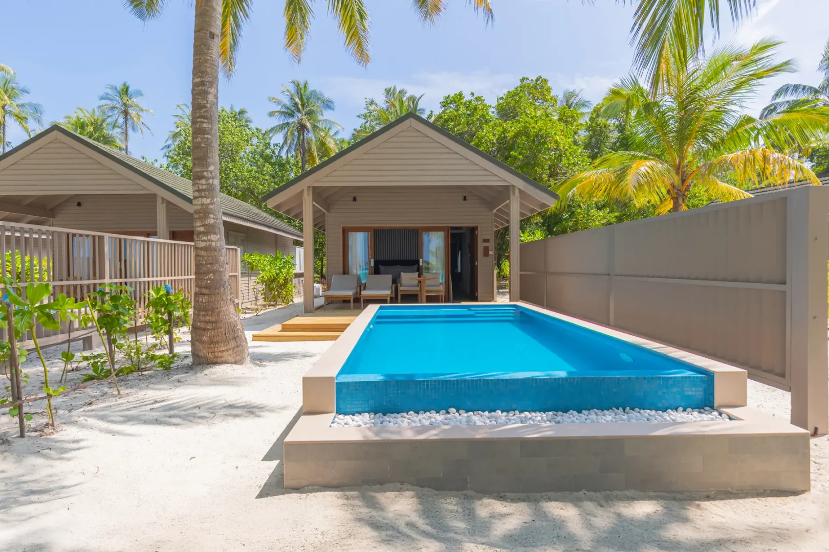 meeru maldives beach pool villa exterior surrounded by tropical greenery with private pool and direct beach access in a serene island setting